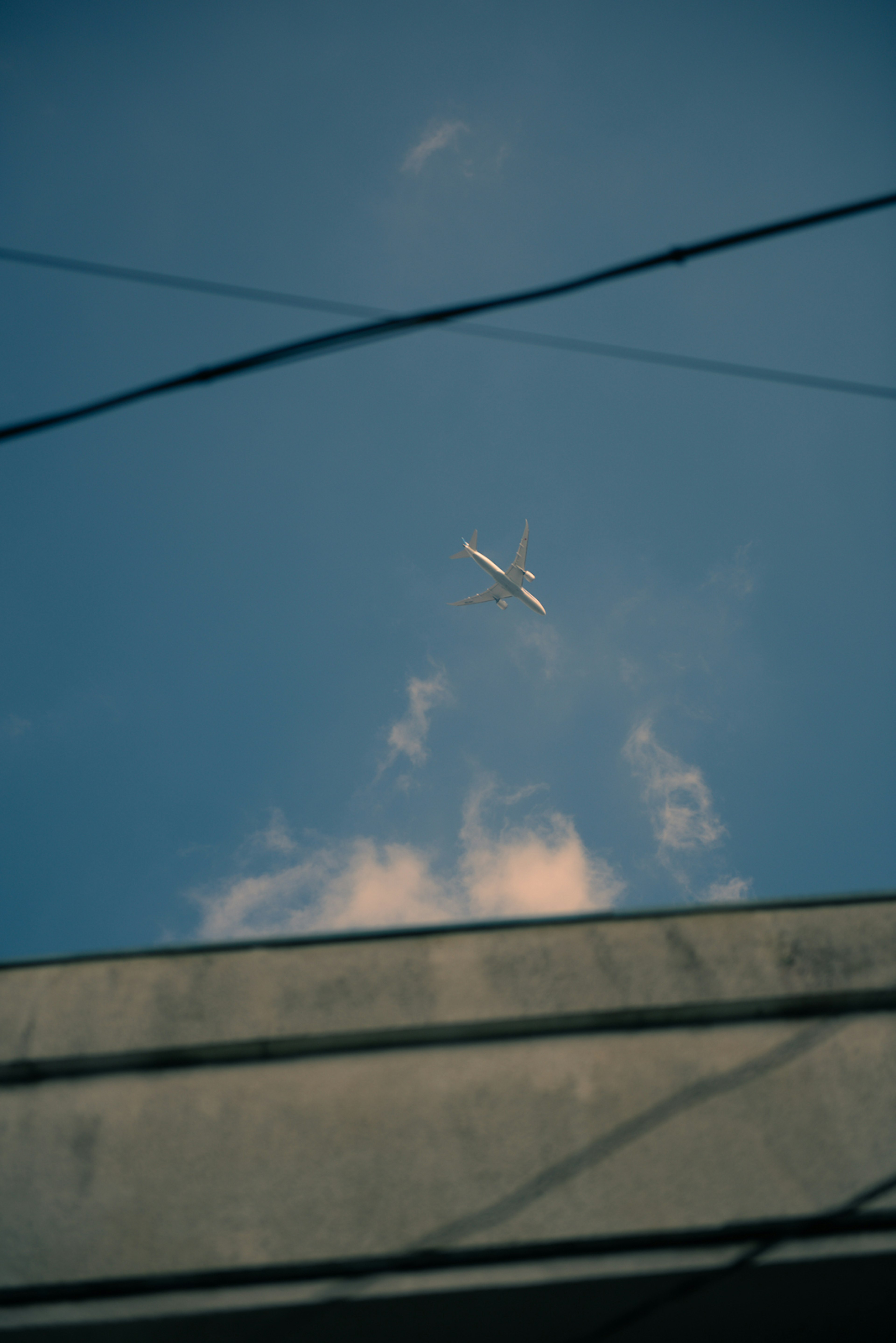 青空に飛ぶ飛行機と雲が見える