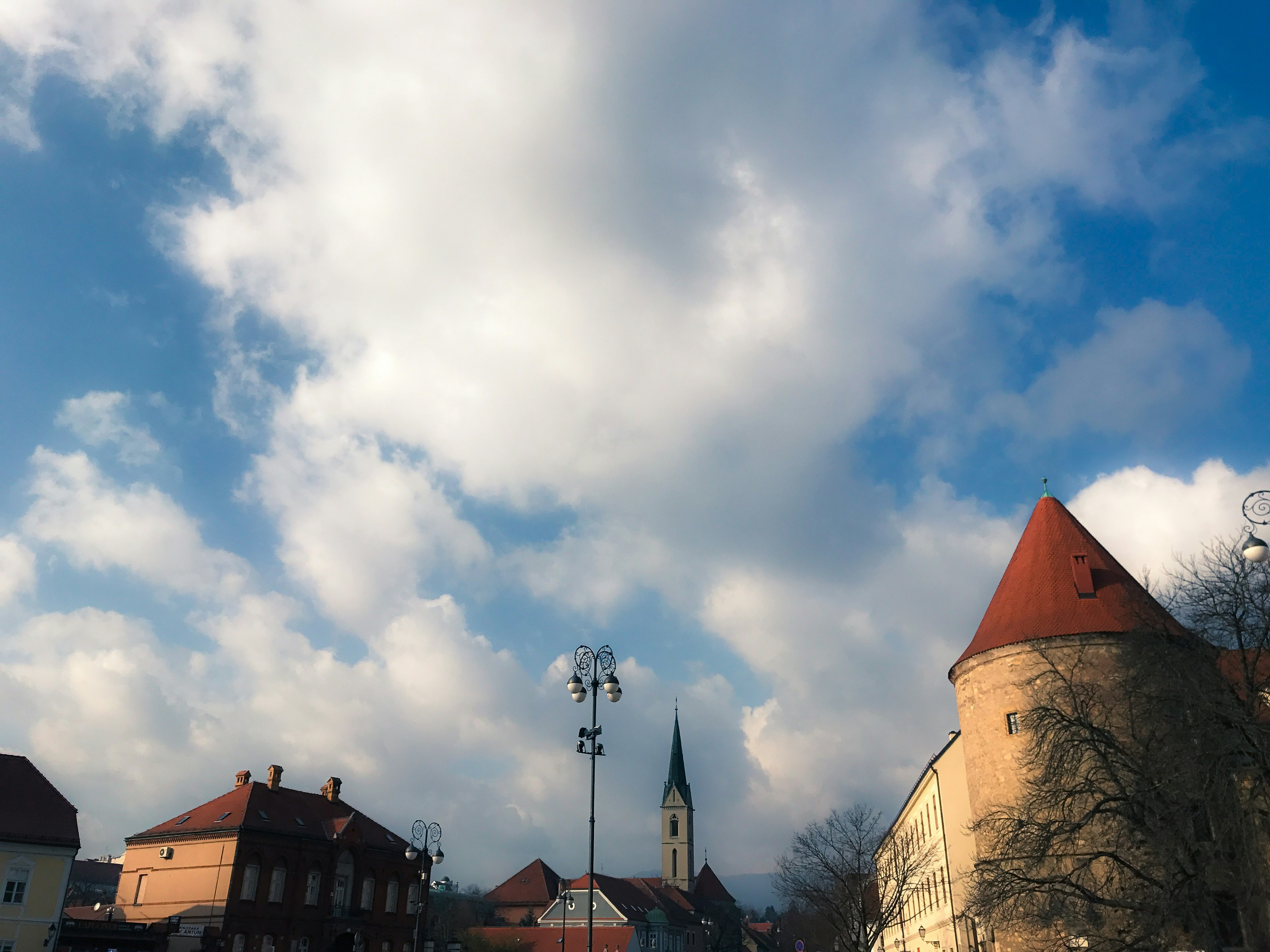 Scenic view with white clouds in blue sky and red-roofed houses