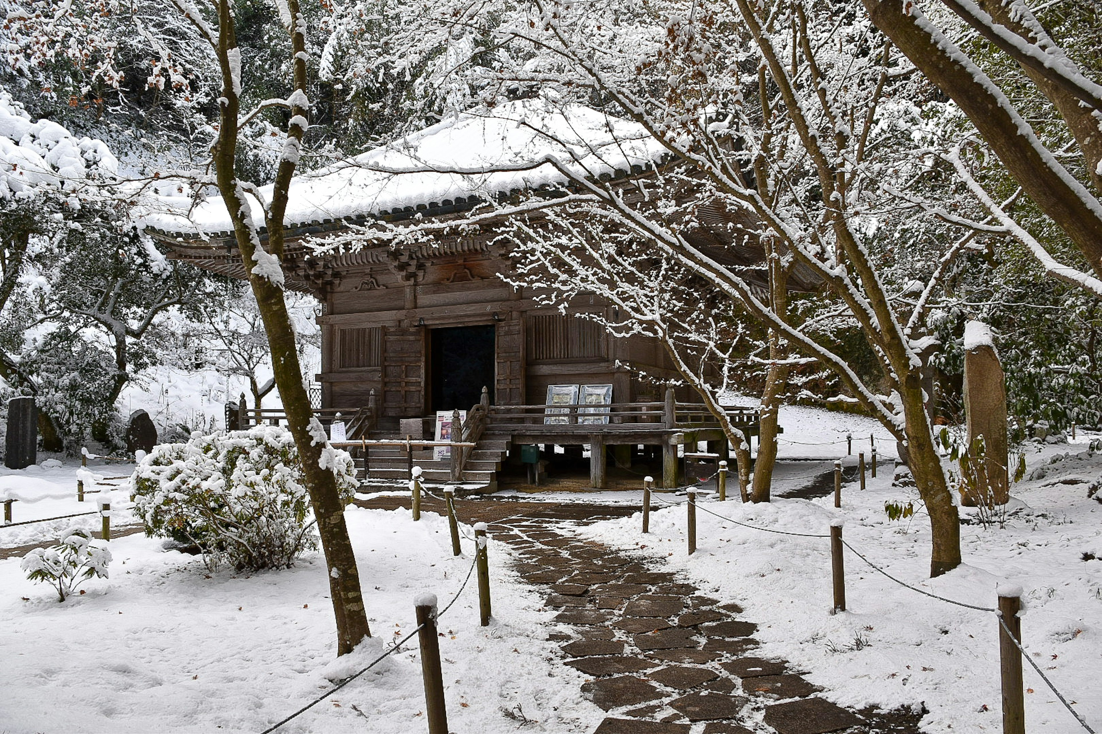 雪に覆われた伝統的な日本の建物と庭