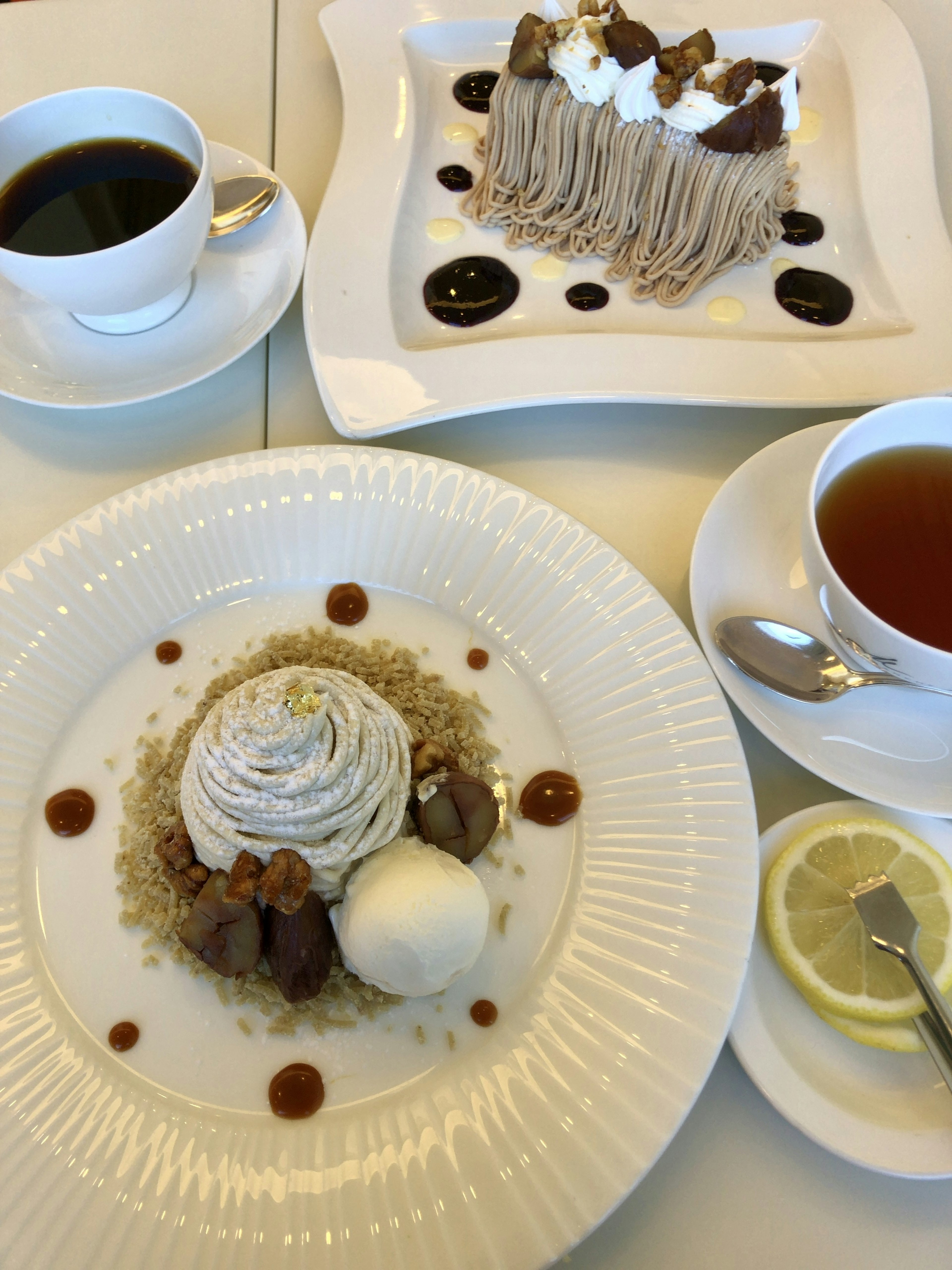 Piring dessert dengan kue Mont Blanc dan es krim disajikan dengan kopi dan teh