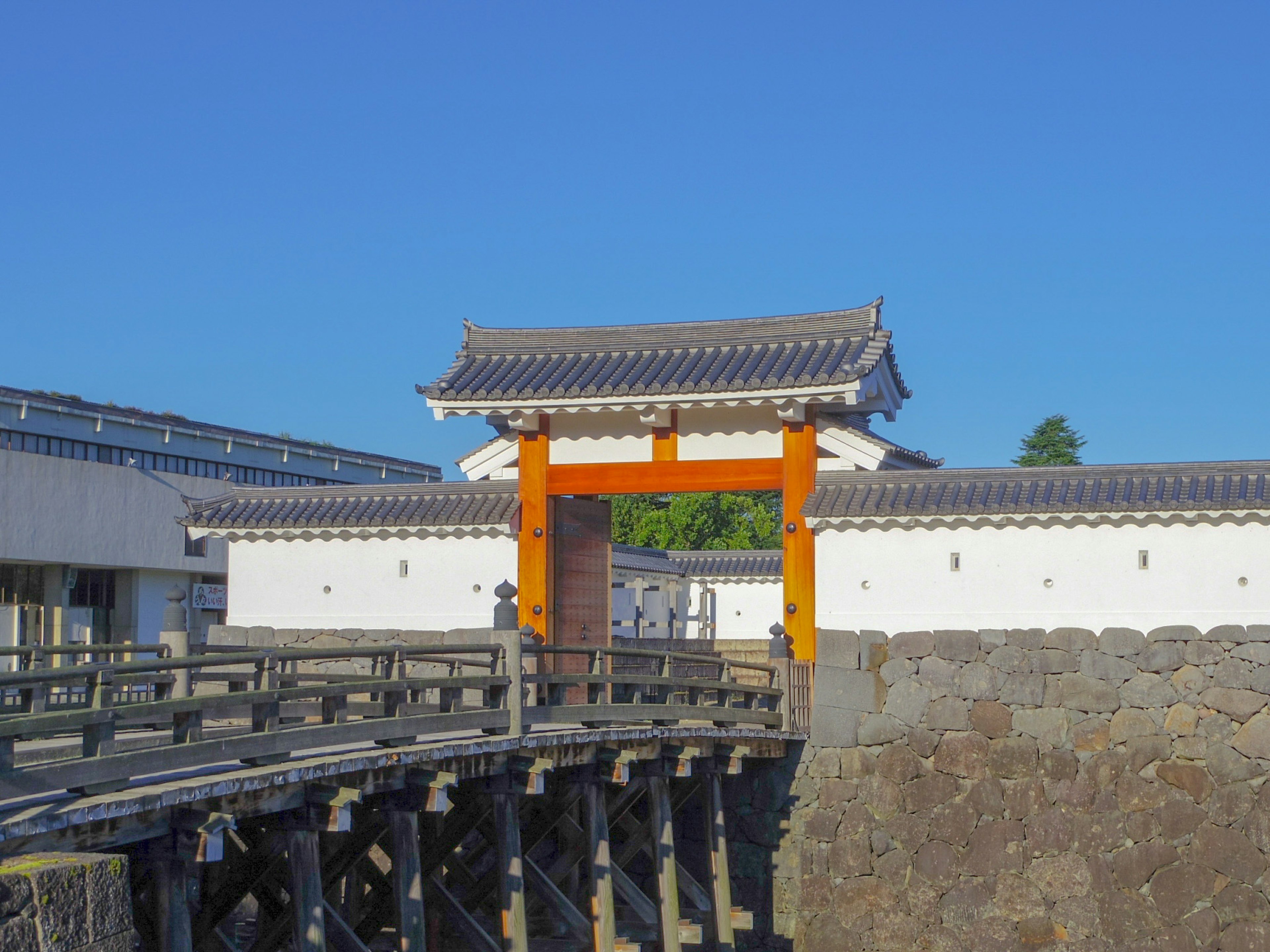 Traditionelles japanisches Tor mit weißen Wänden unter einem klaren blauen Himmel