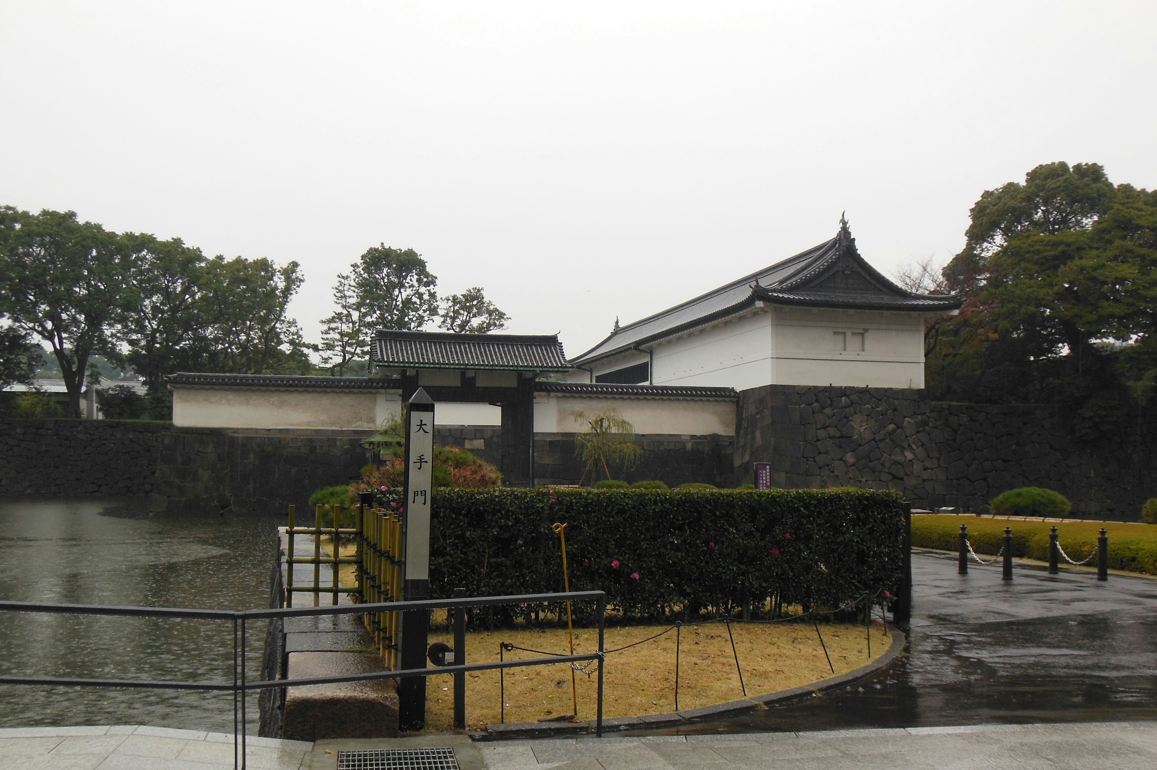 Vista exterior del palacio imperial de Tokio con lluvia y jardín