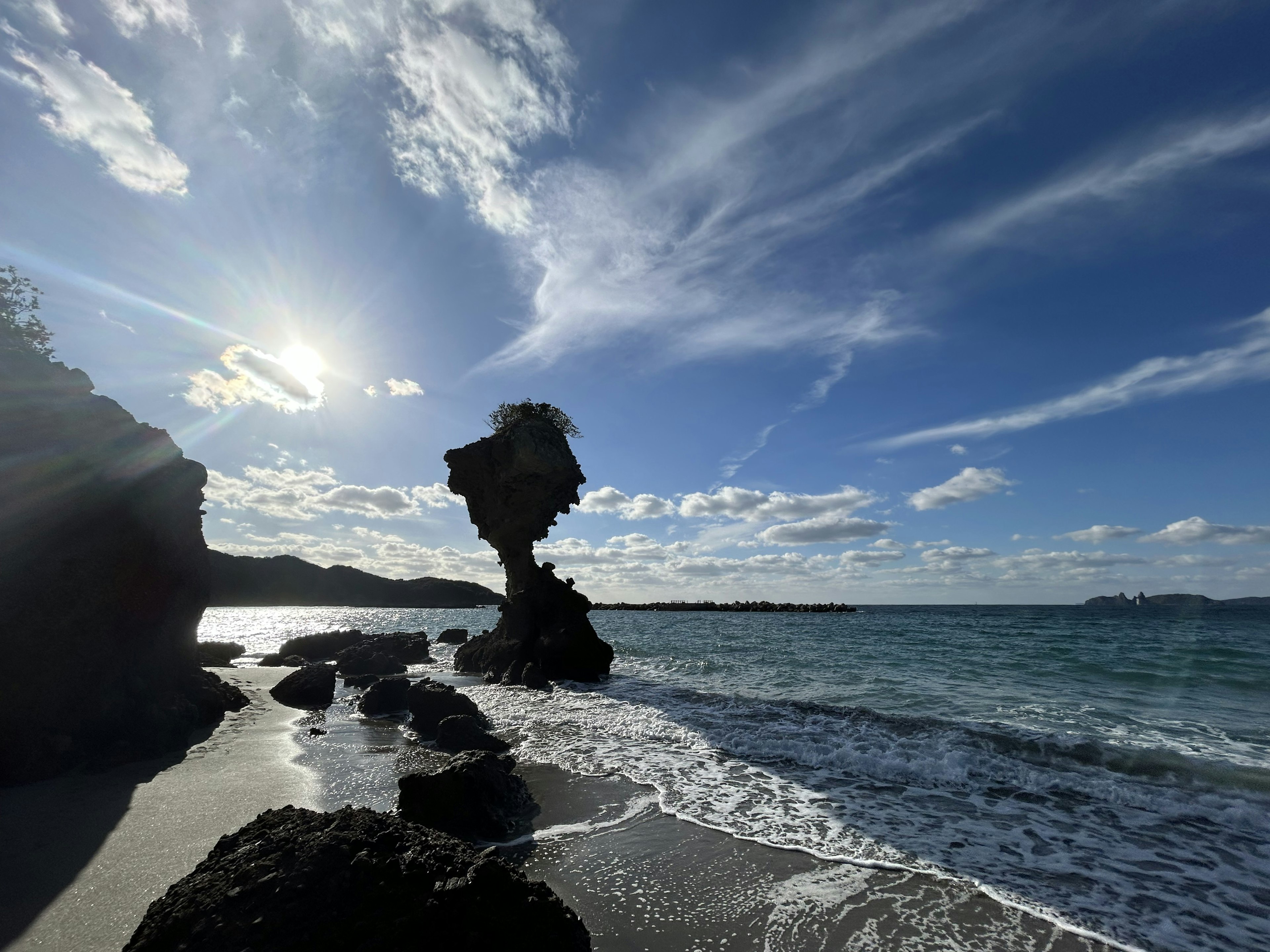 Unique rock formation at the beach with waves and sunlight