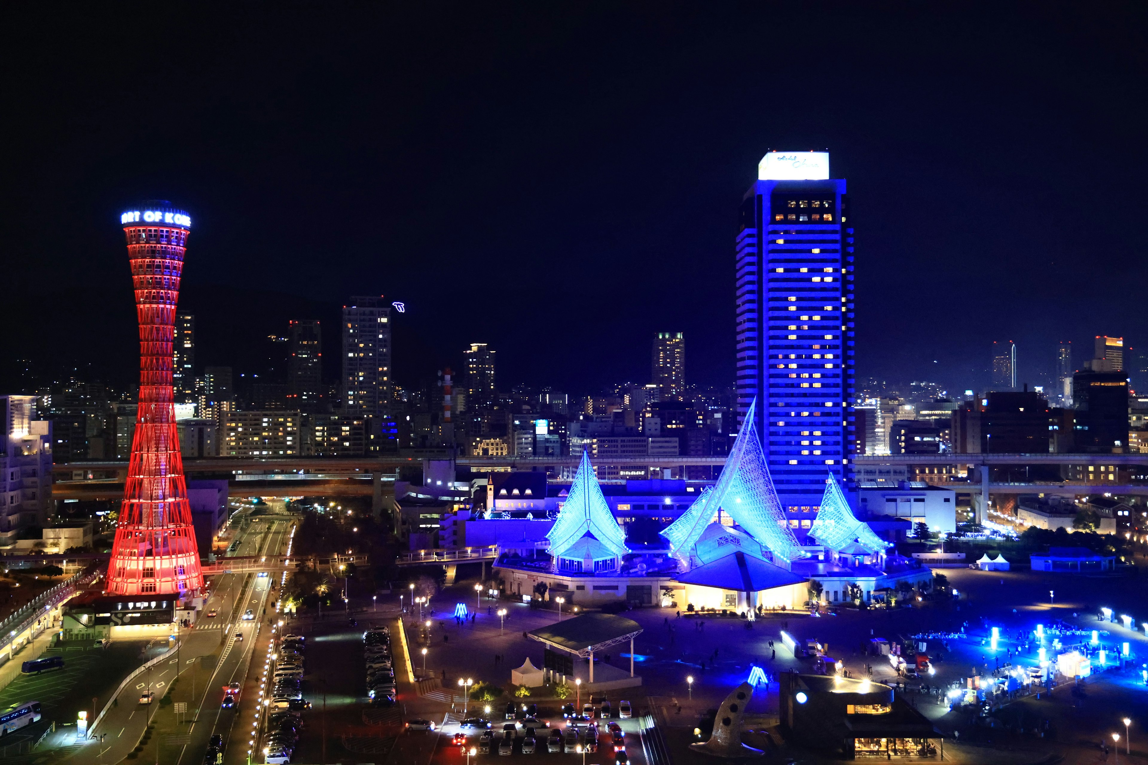 Pemandangan malam Kobe dengan bangunan yang diterangi dan menara merah