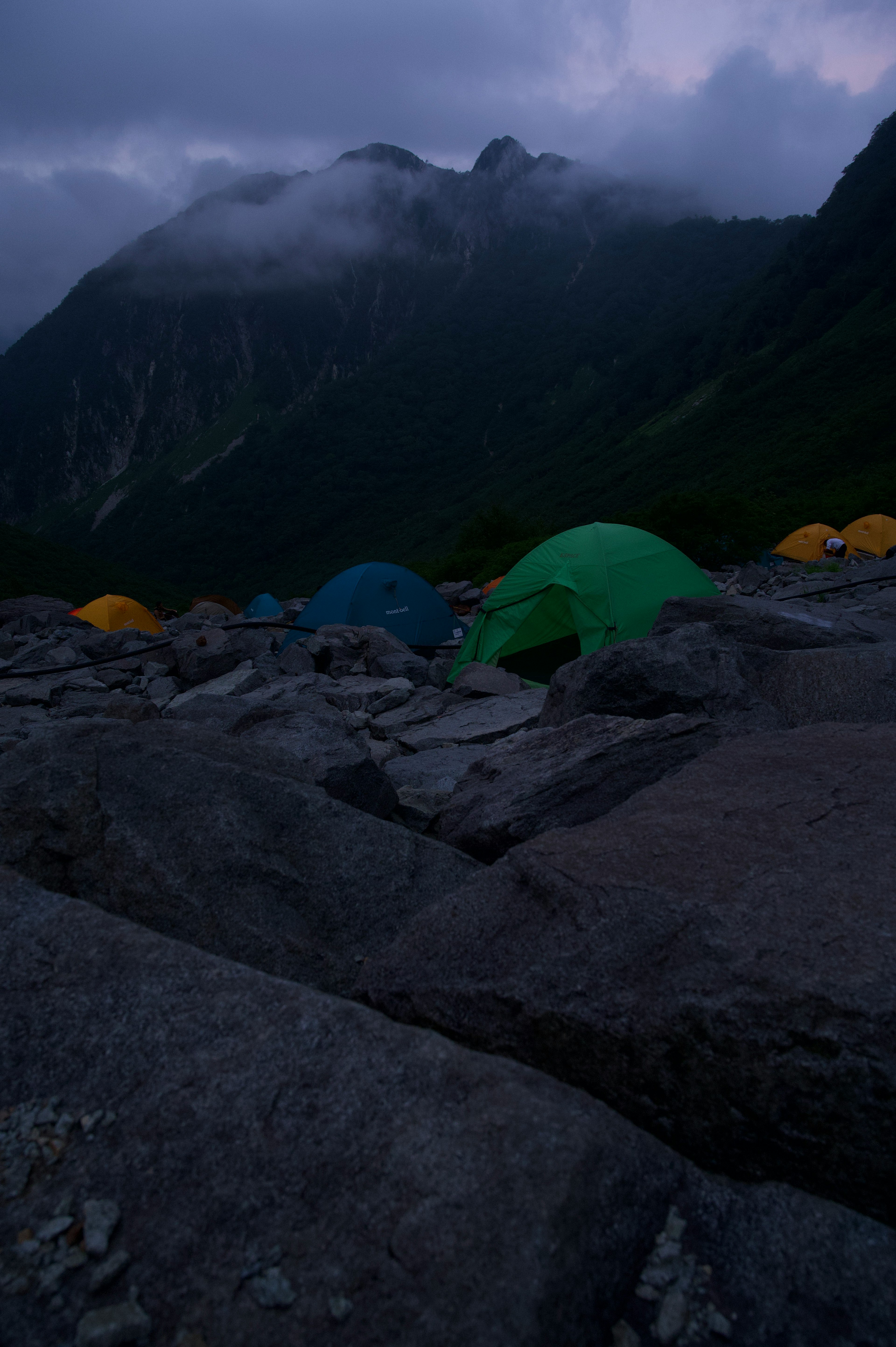 暗い山の風景にテントが並ぶシーン