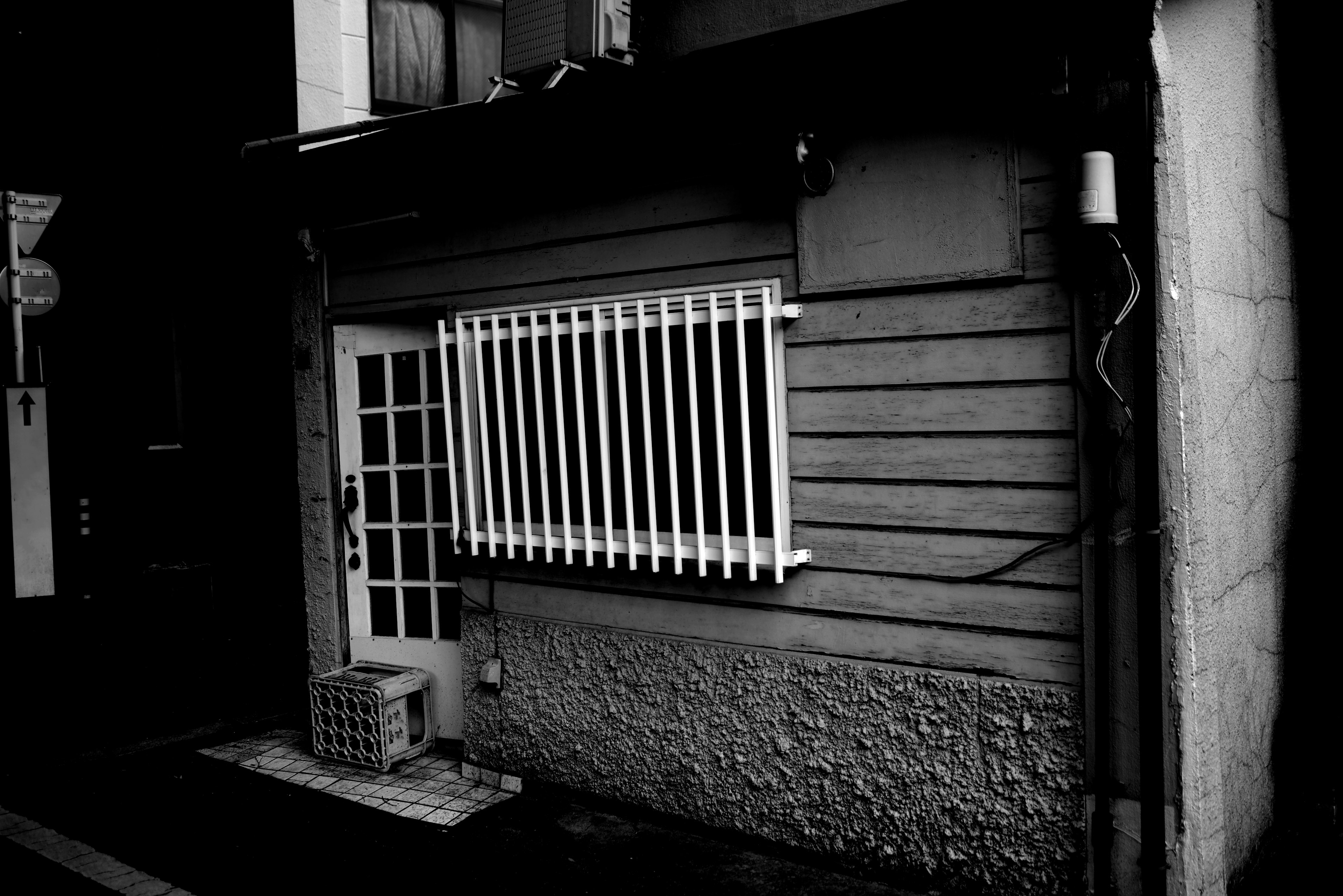 Exterior of an old wooden building with distinctive white bars