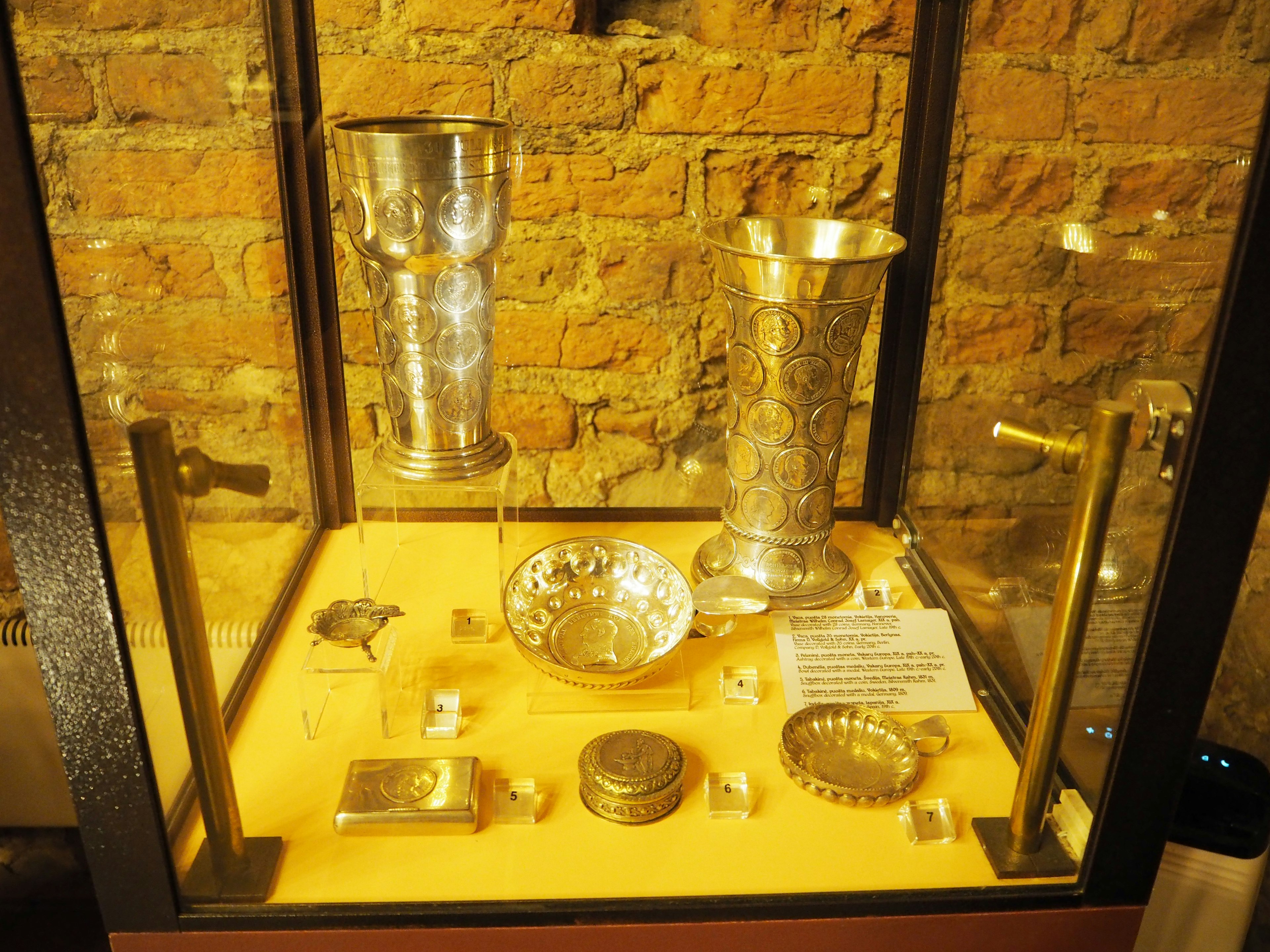 Colección de artefactos de plata exhibidos en una vitrina de vidrio