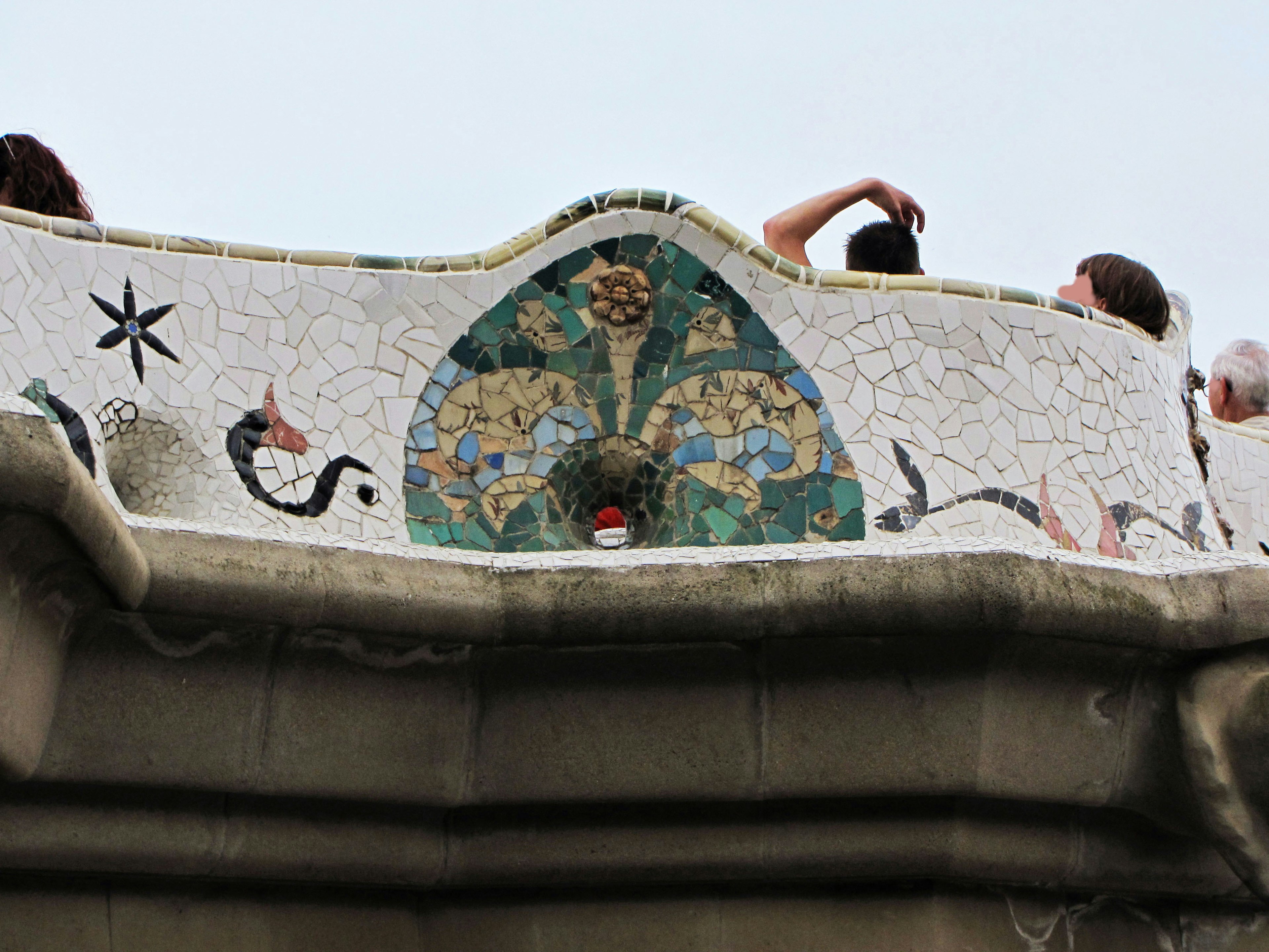 Mosaic decoration on a building rooftop with visitors