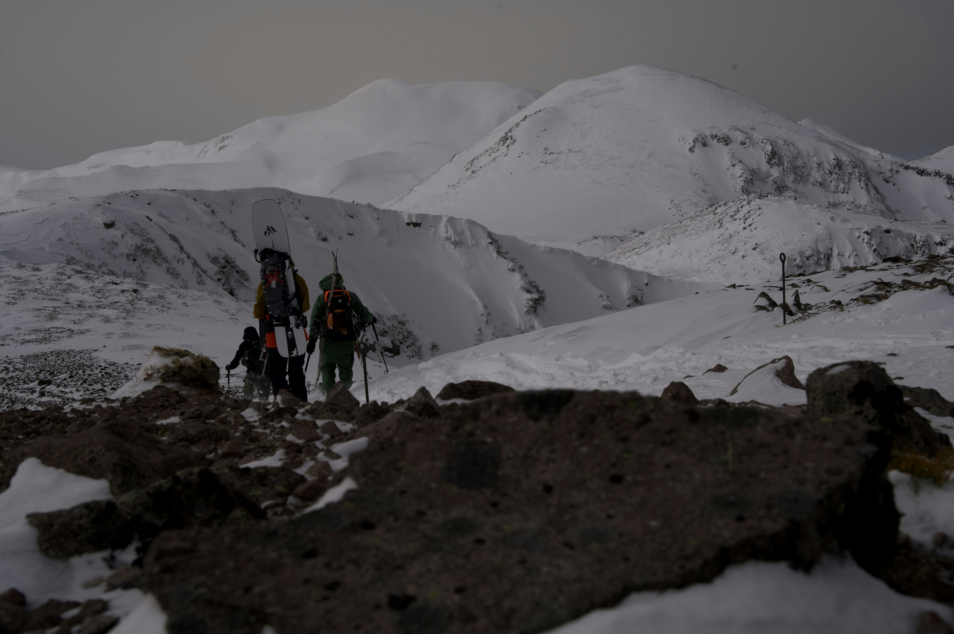 Excursionistas caminando en un paisaje montañoso nevado