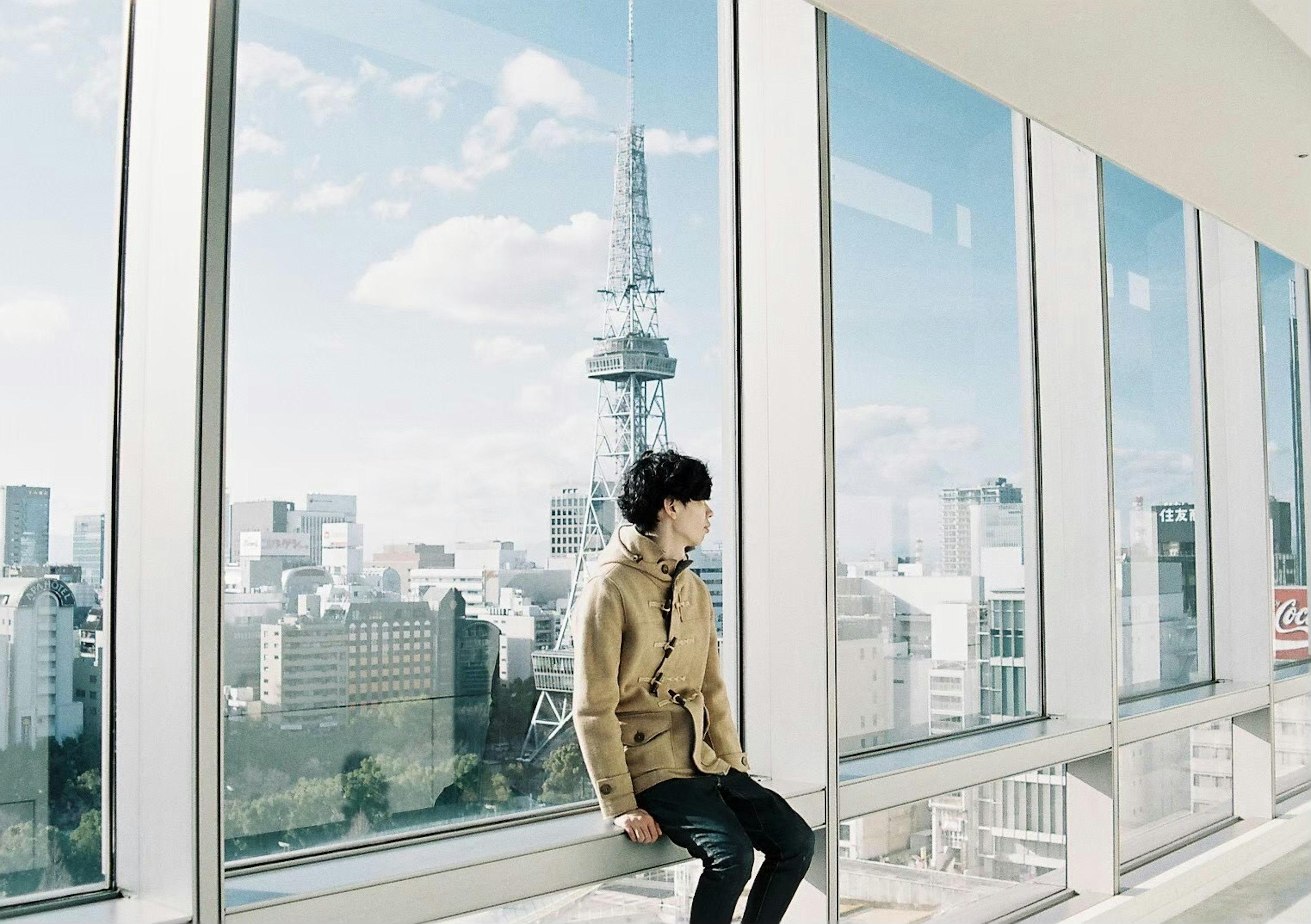 Man sitting by the window with a view of Tokyo Tower