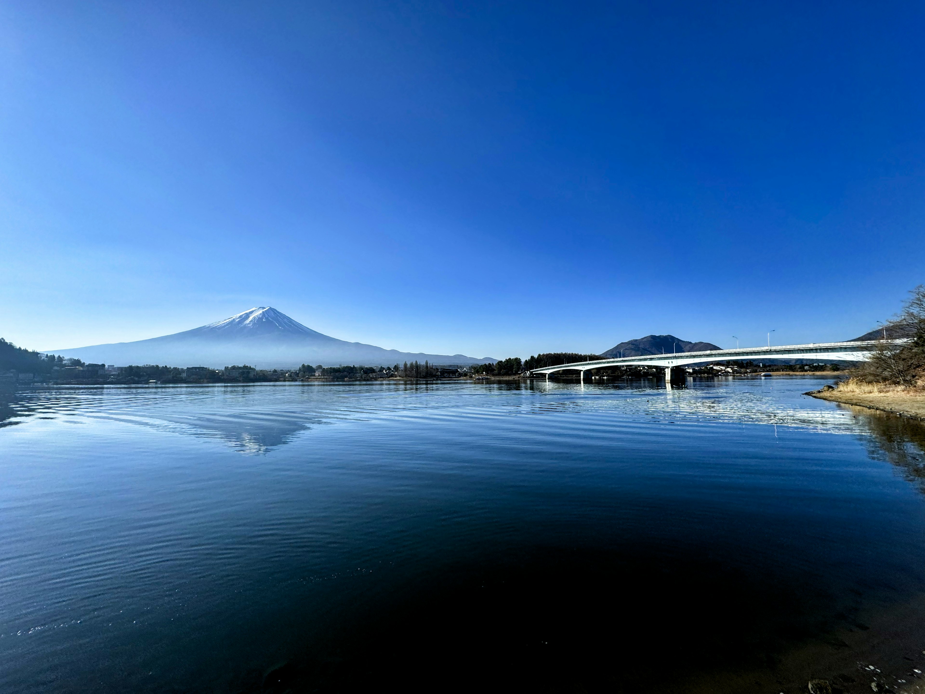 Scenic view of Mount Fuji reflecting on the lake under a clear blue sky