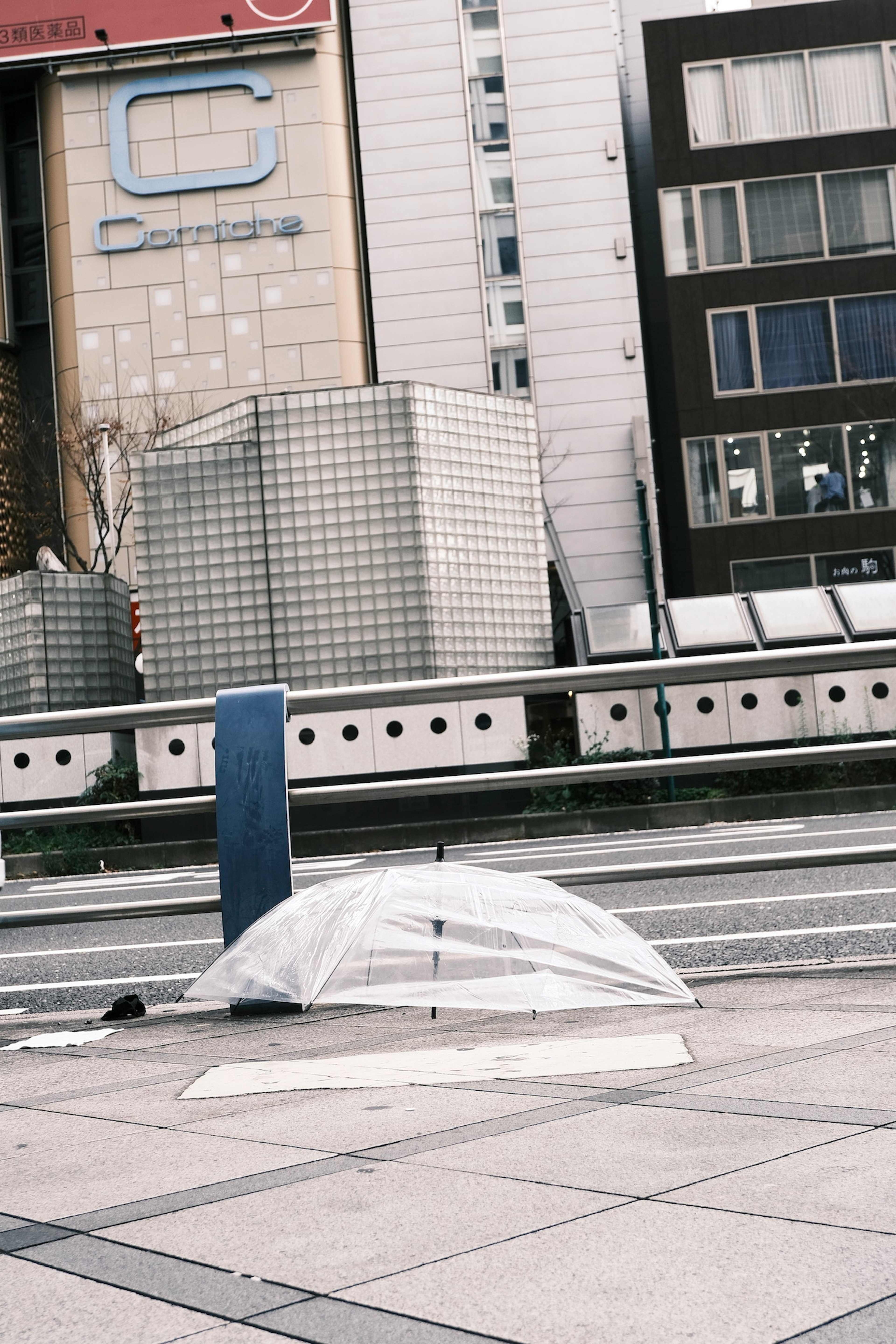 Un parapluie transparent posé au sol dans un cadre urbain