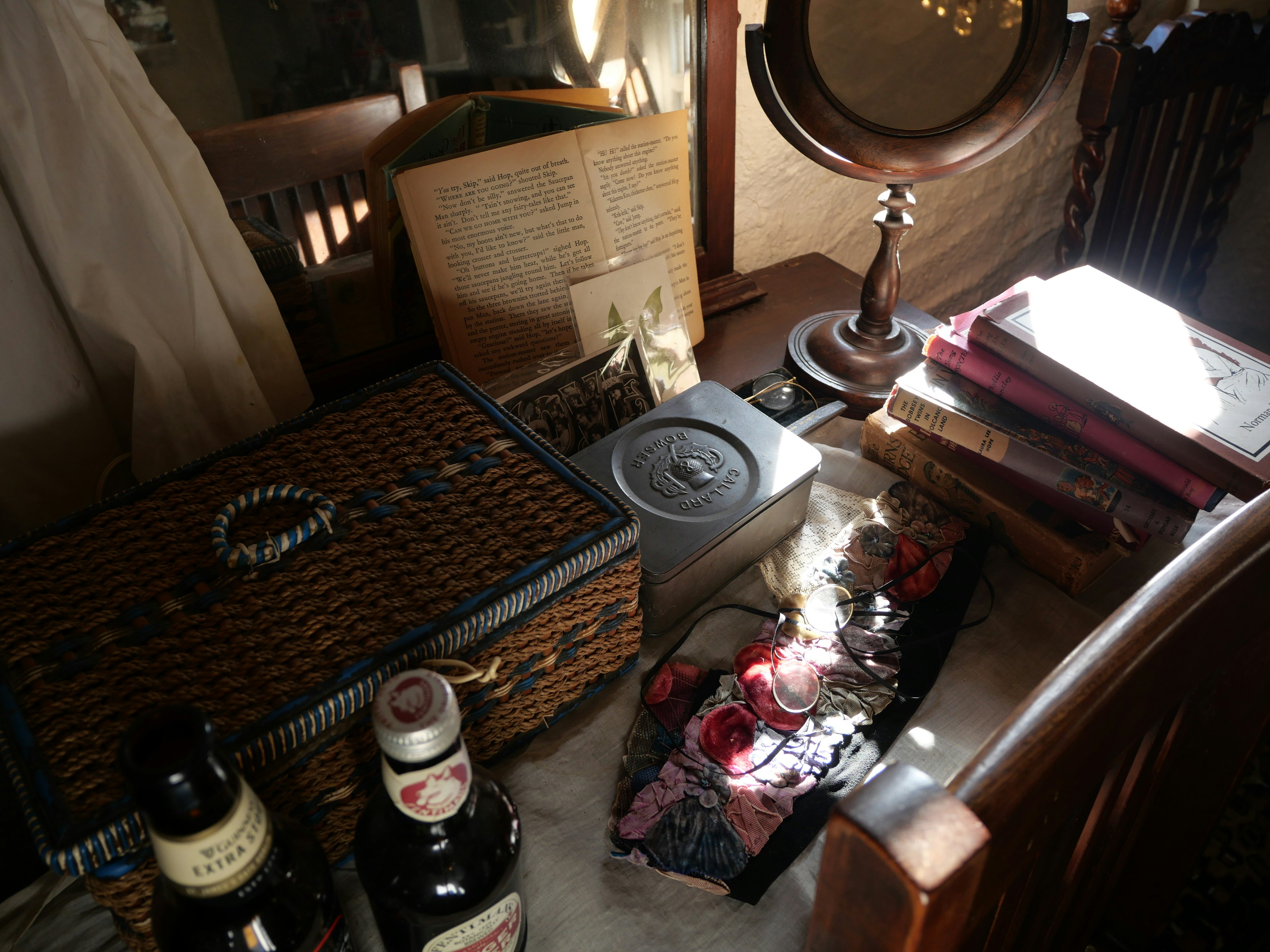 Various objects and bottles on an old piece of furniture with sunlight streaming in