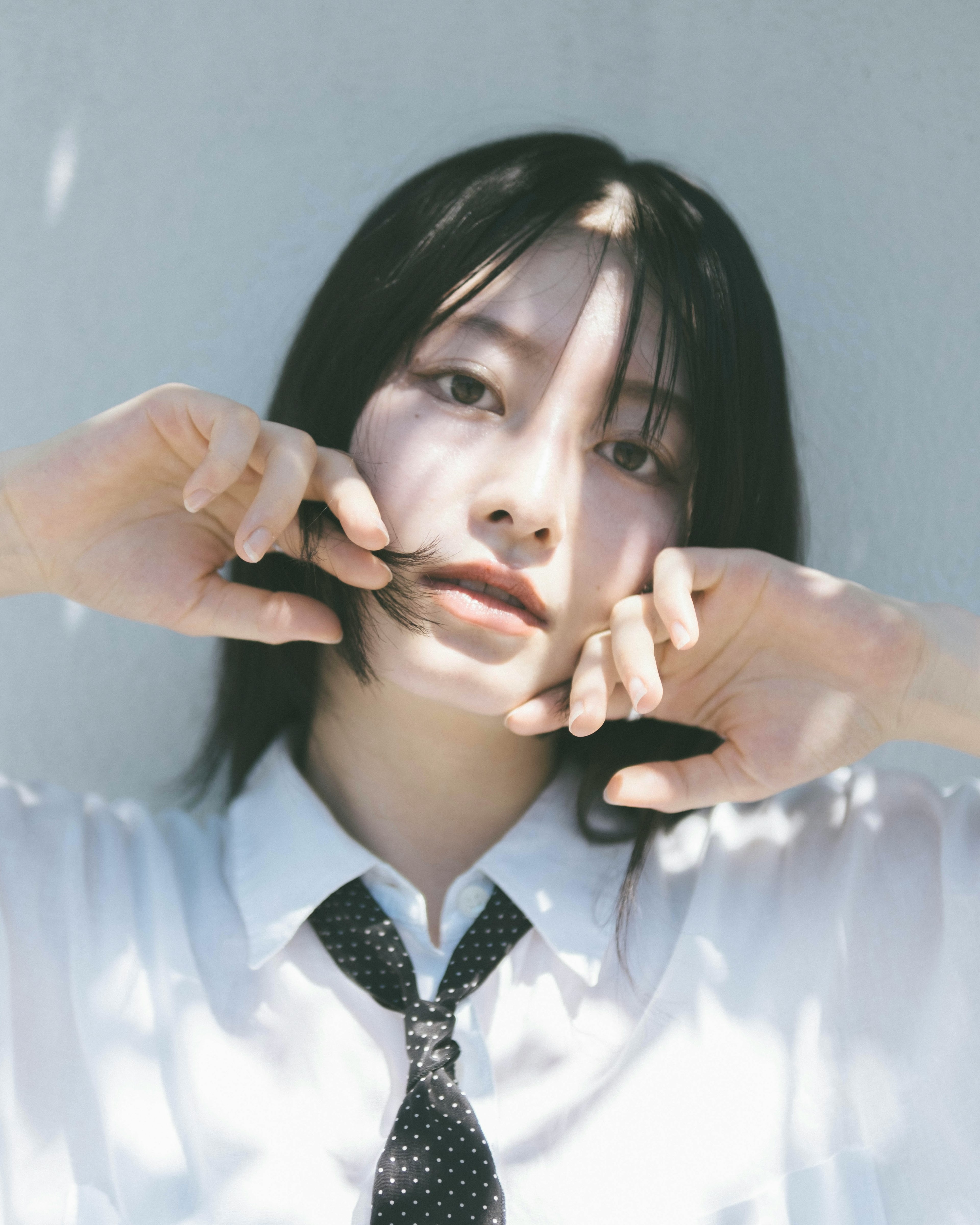 Portrait of a woman wearing a white shirt and tie Soft light filters through the background