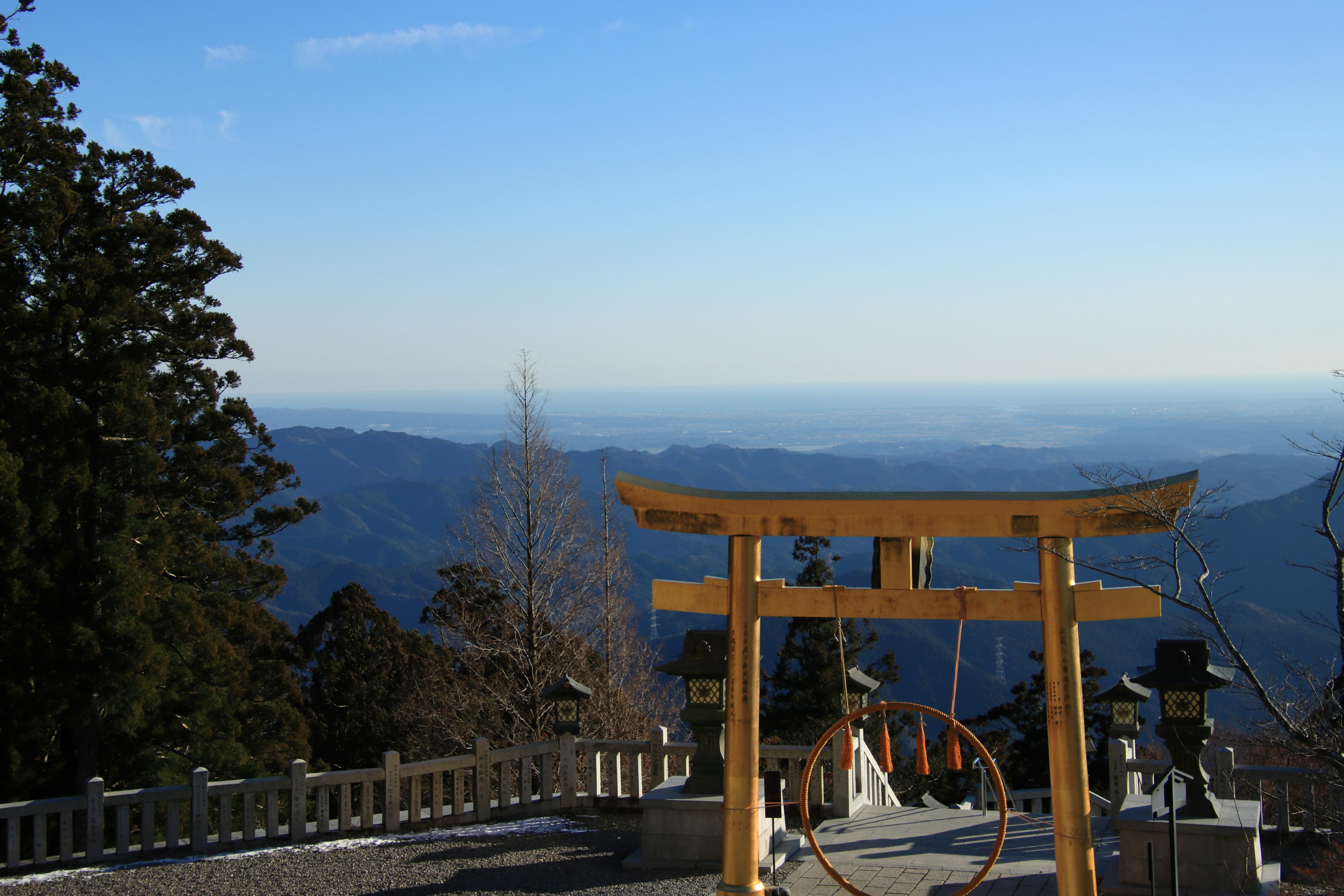 Cổng torii với cảnh núi dưới bầu trời xanh