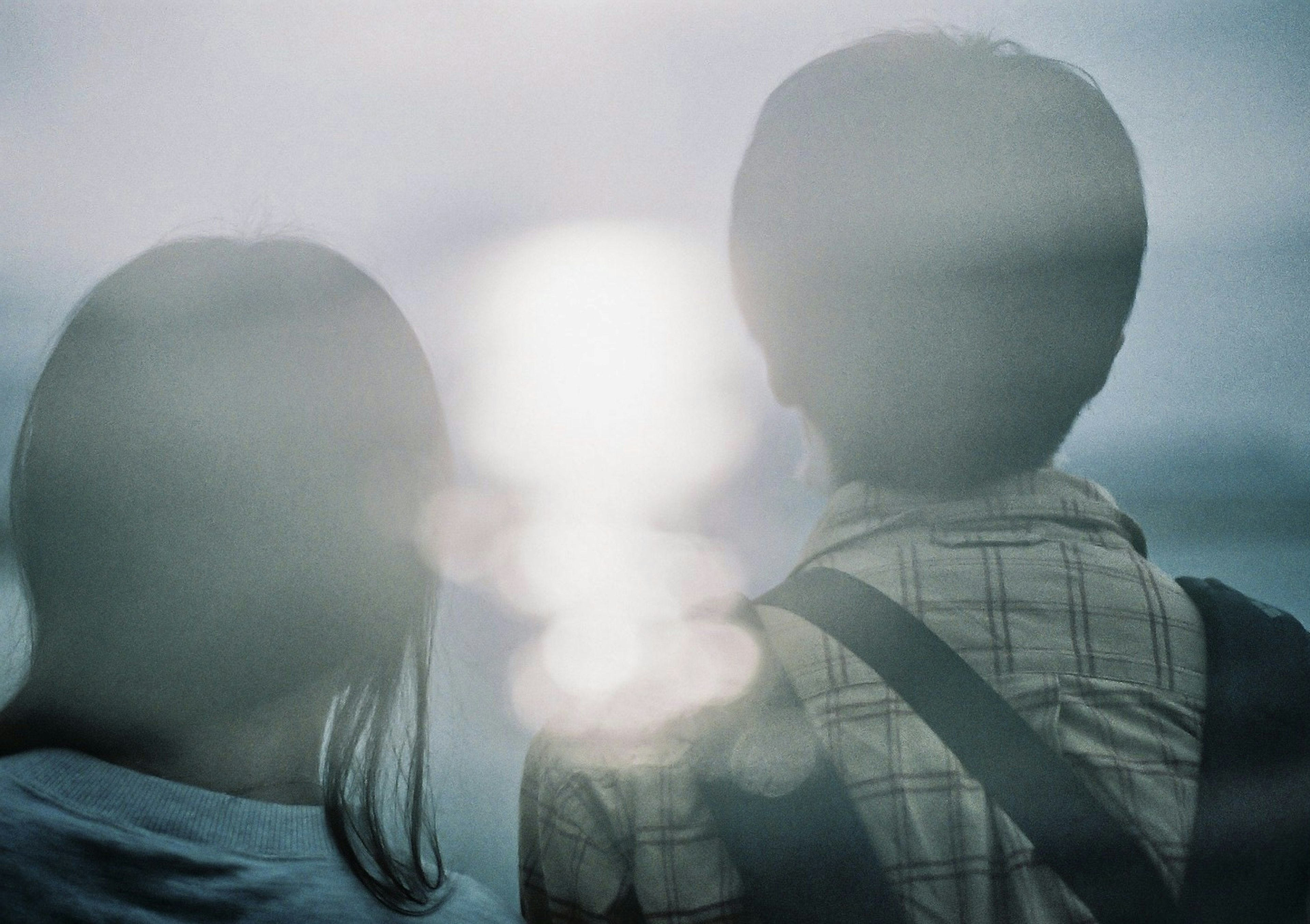 Two people gazing at a blurred ocean