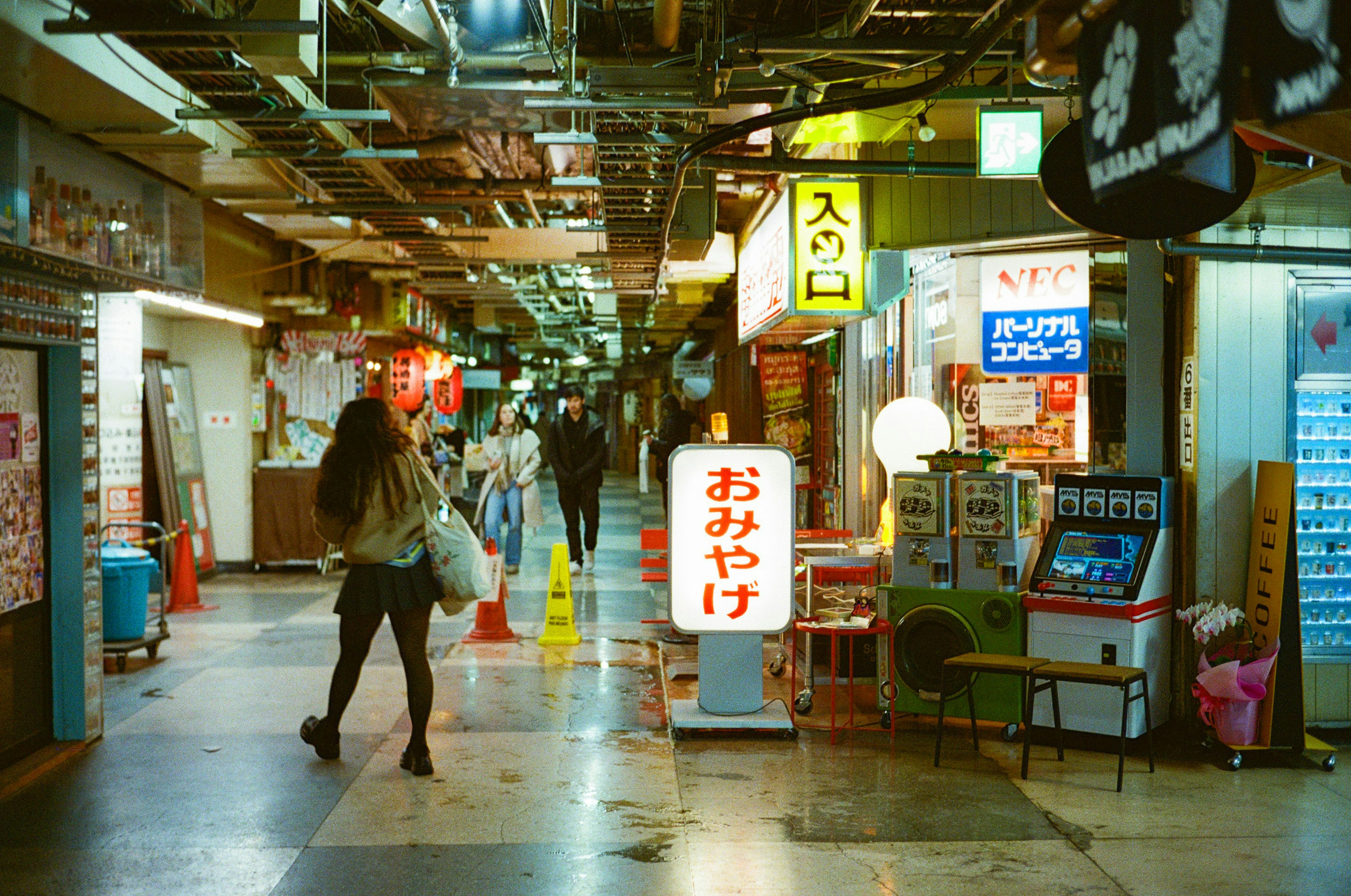 Underground shopping arcade with neon signs and dining establishments