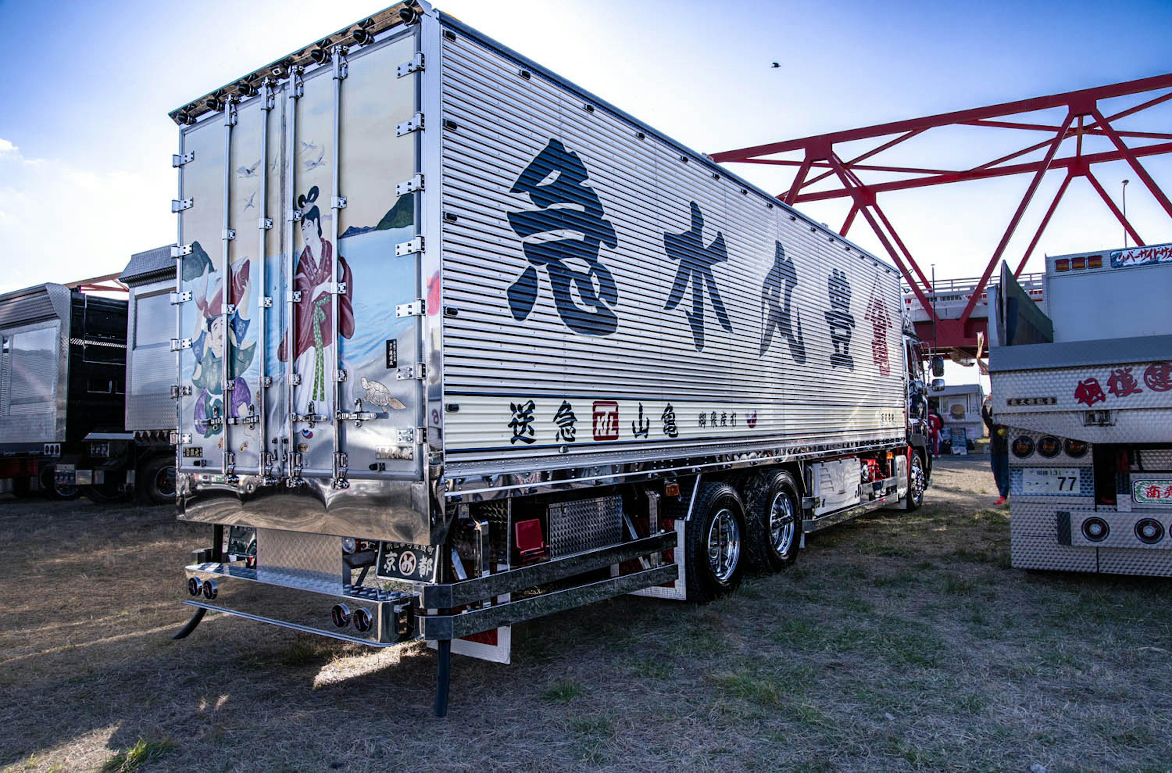 Truk trailer perak dengan huruf Jepang di samping