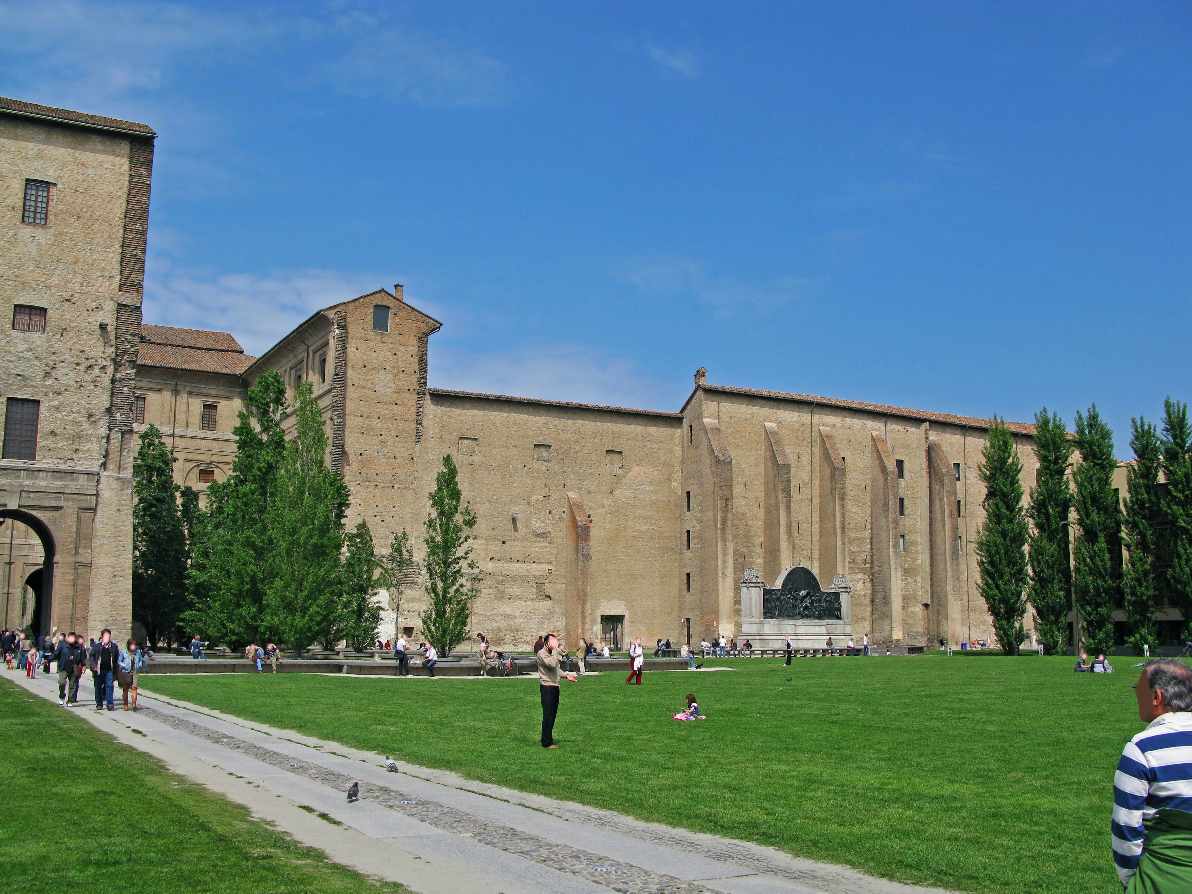 Façade d'un bâtiment historique entouré d'une pelouse verte et d'un ciel bleu