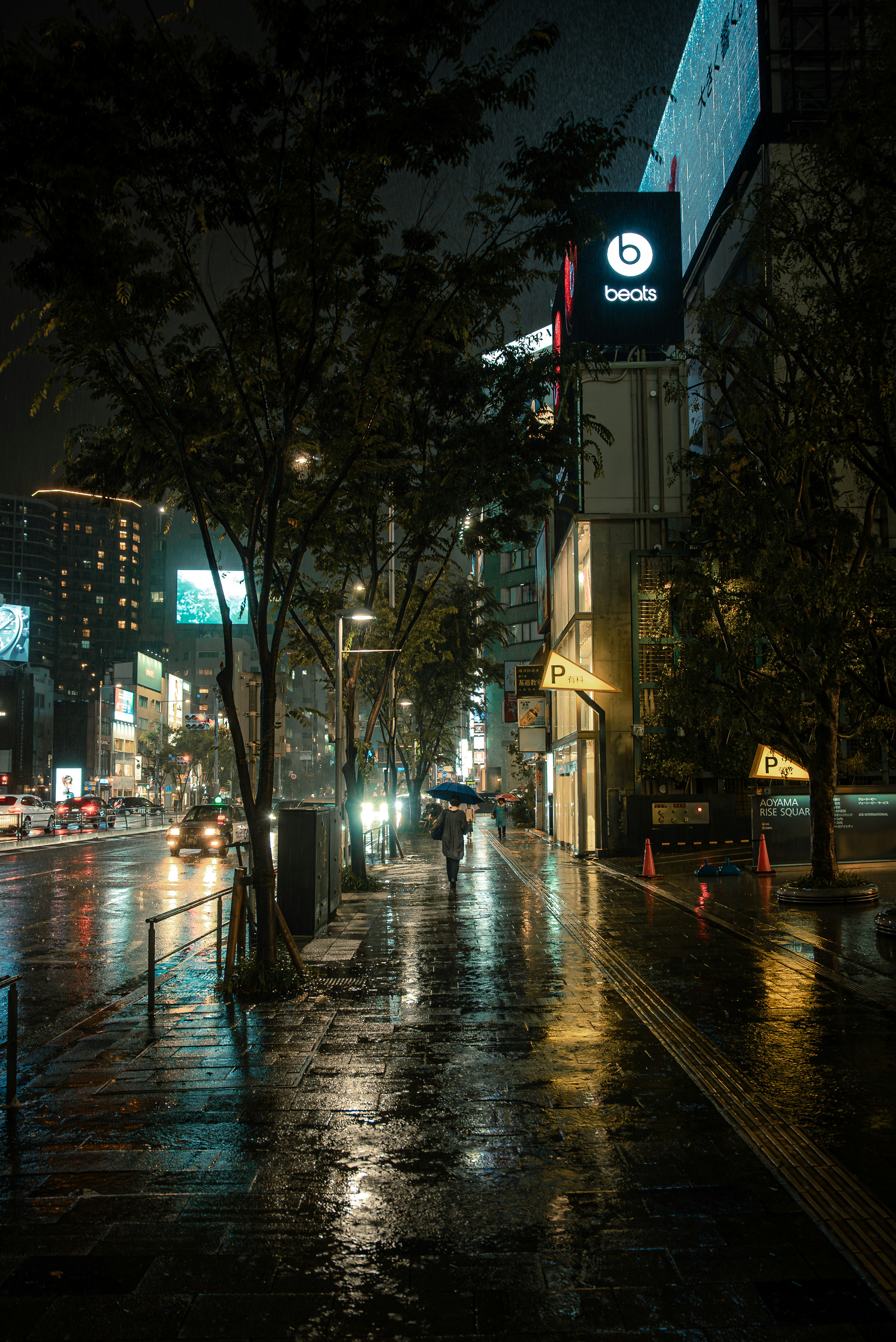 Paesaggio urbano notturno piovoso con marciapiede lucido e lampioni