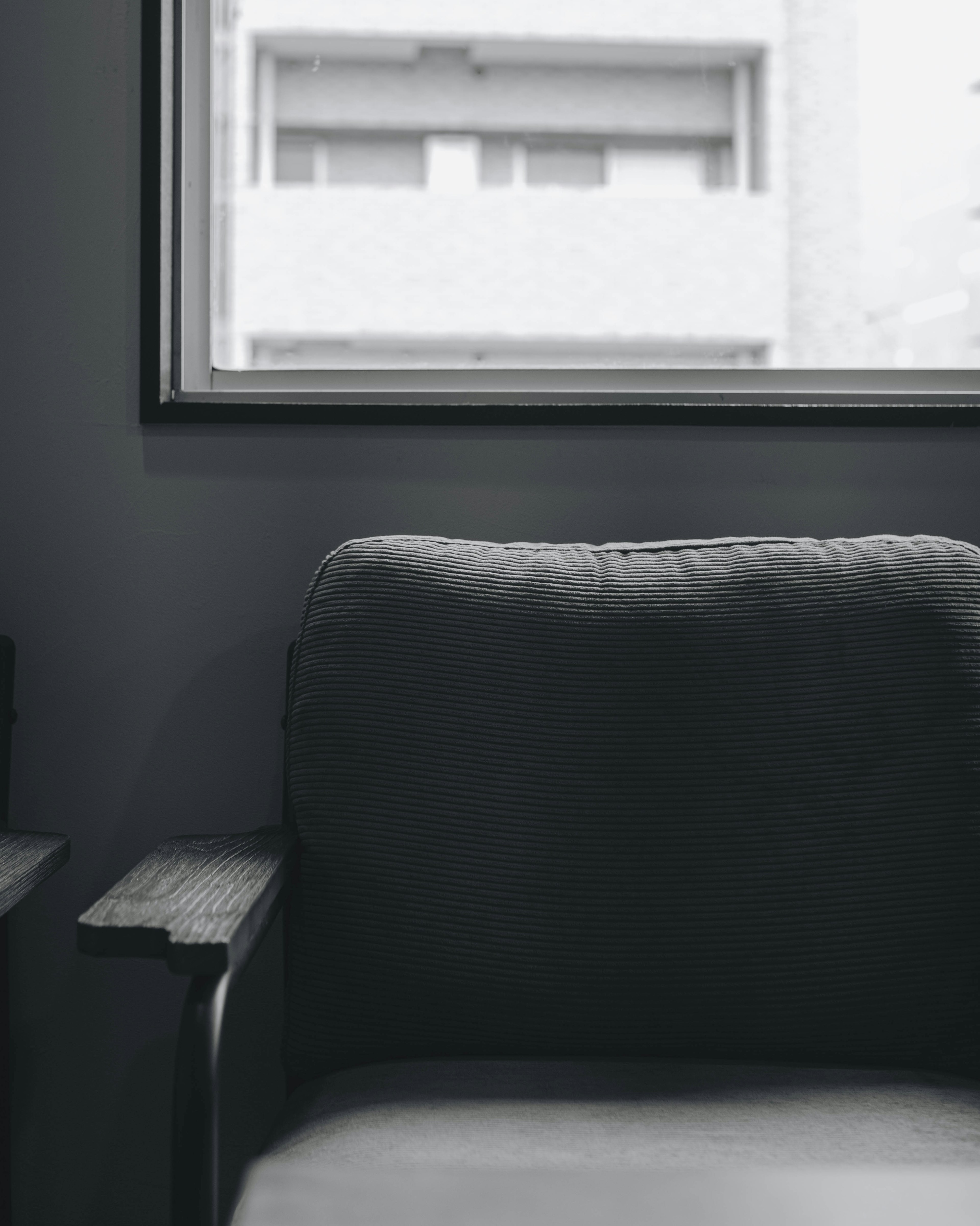 Minimalist interior featuring a gray sofa and a large window