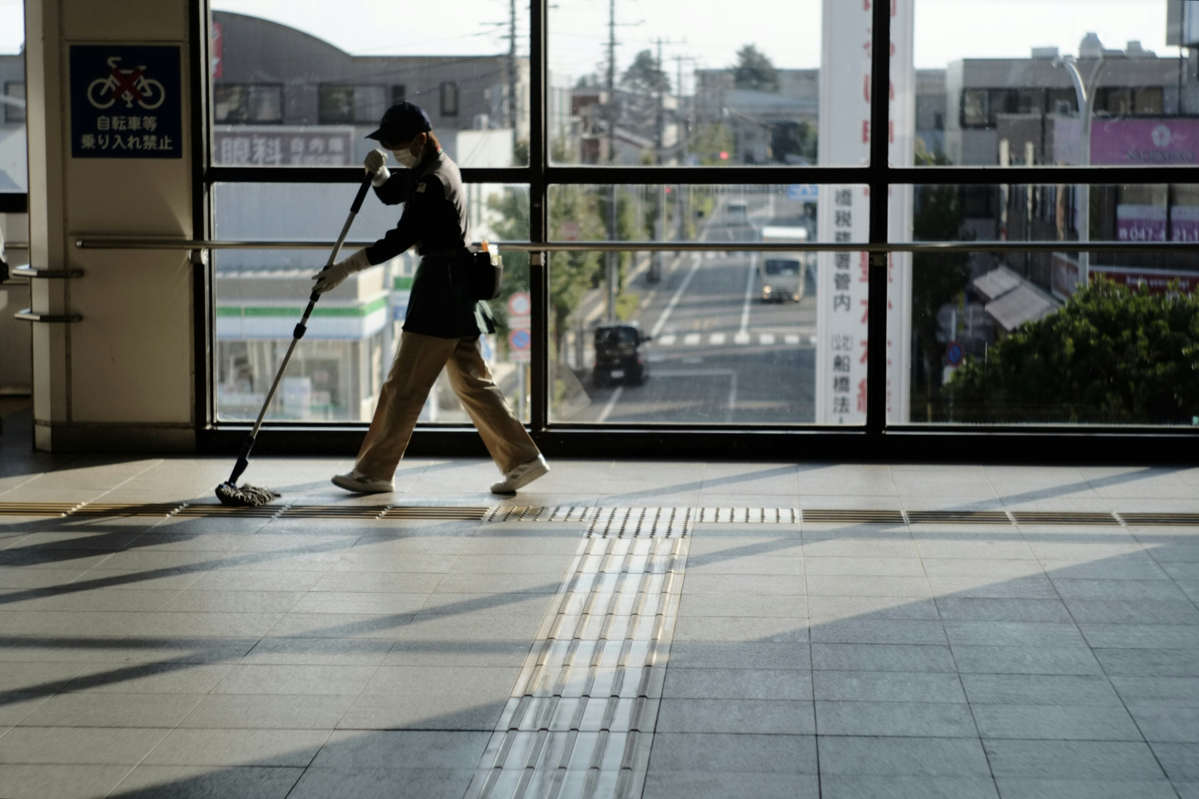 駅の構内で掃除をする作業員の姿が見える