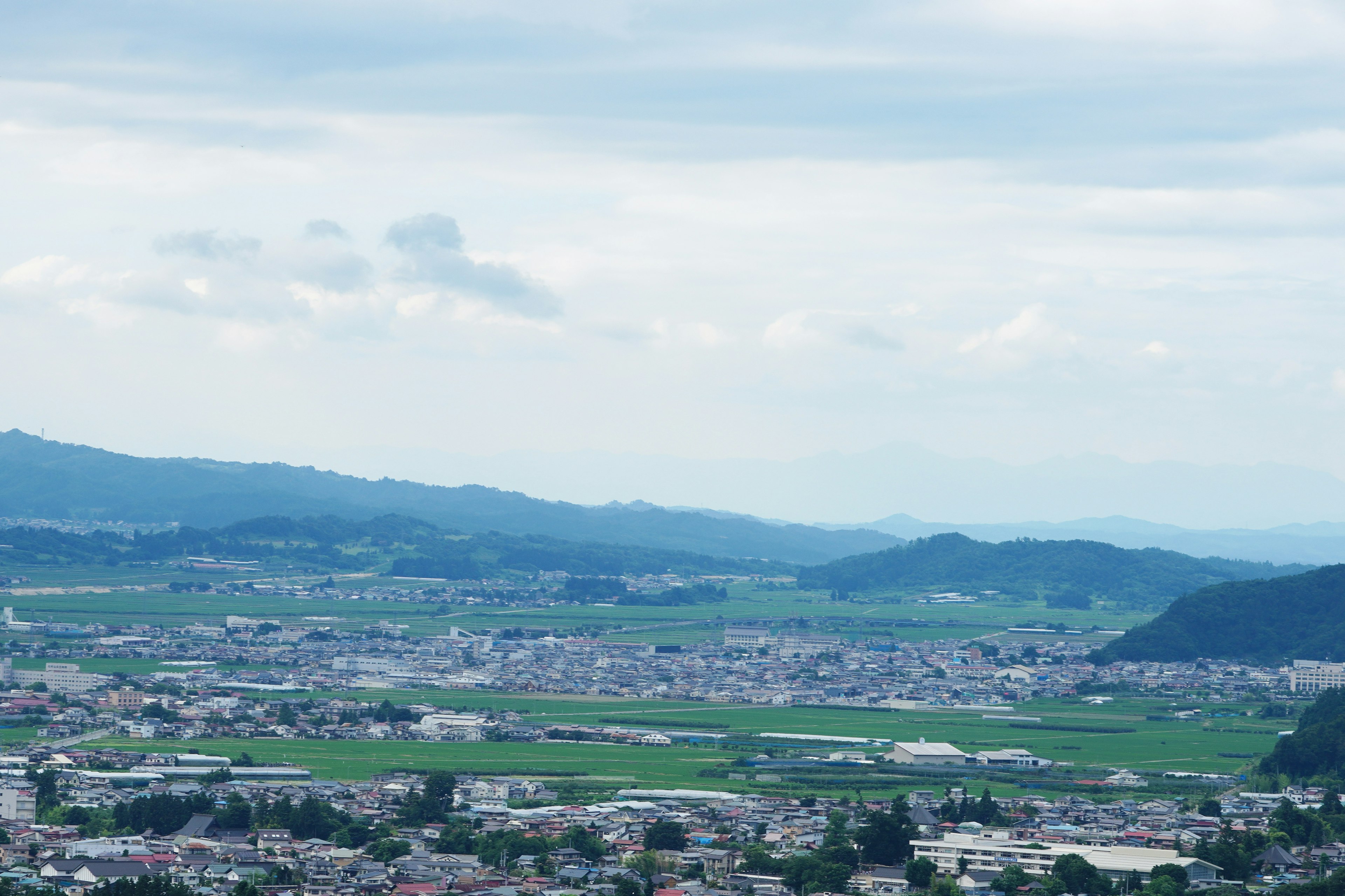 Scenic view of lush fields and distant mountains