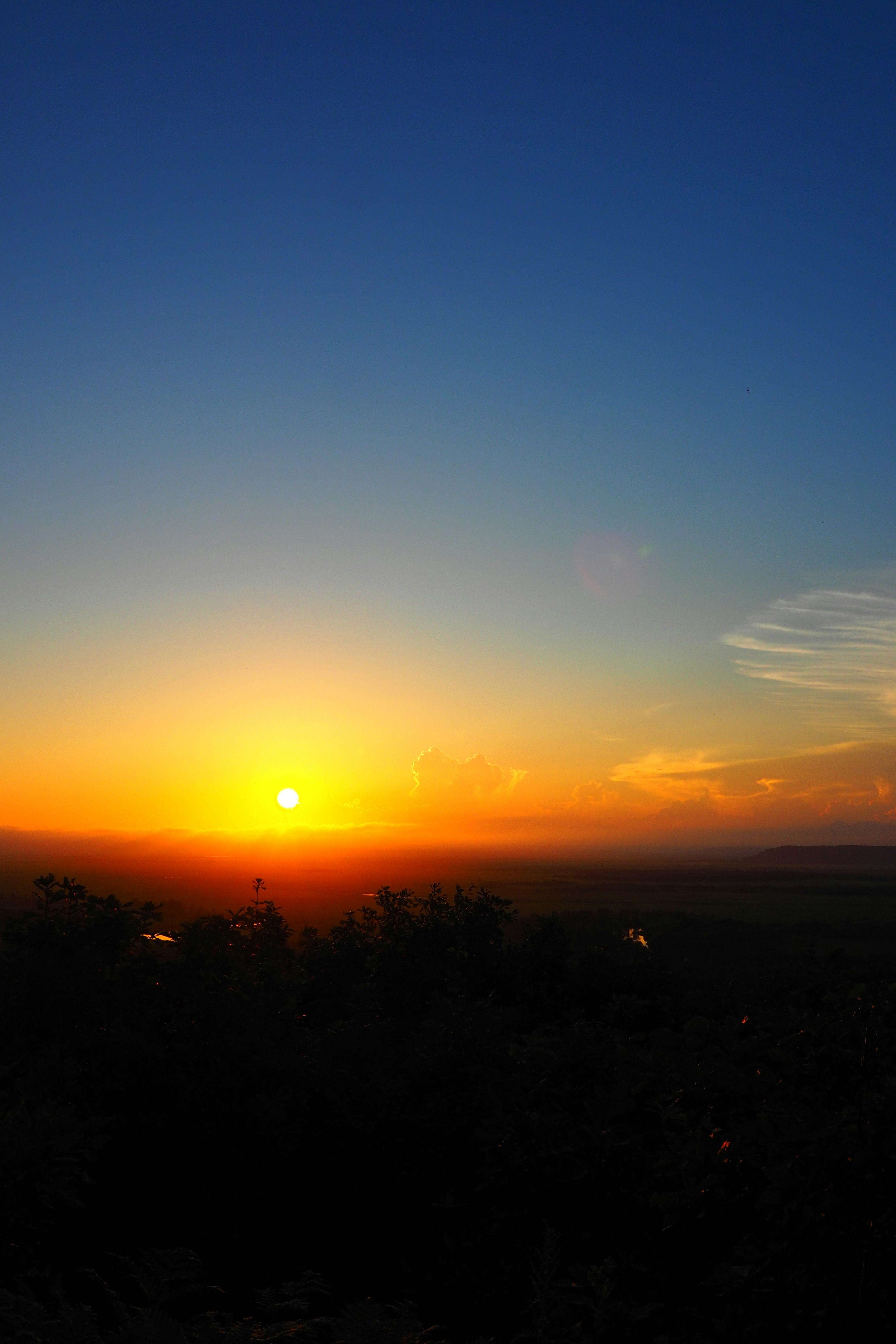 Sonnenuntergang über einem klaren Himmel mit Orange- und Blautönen