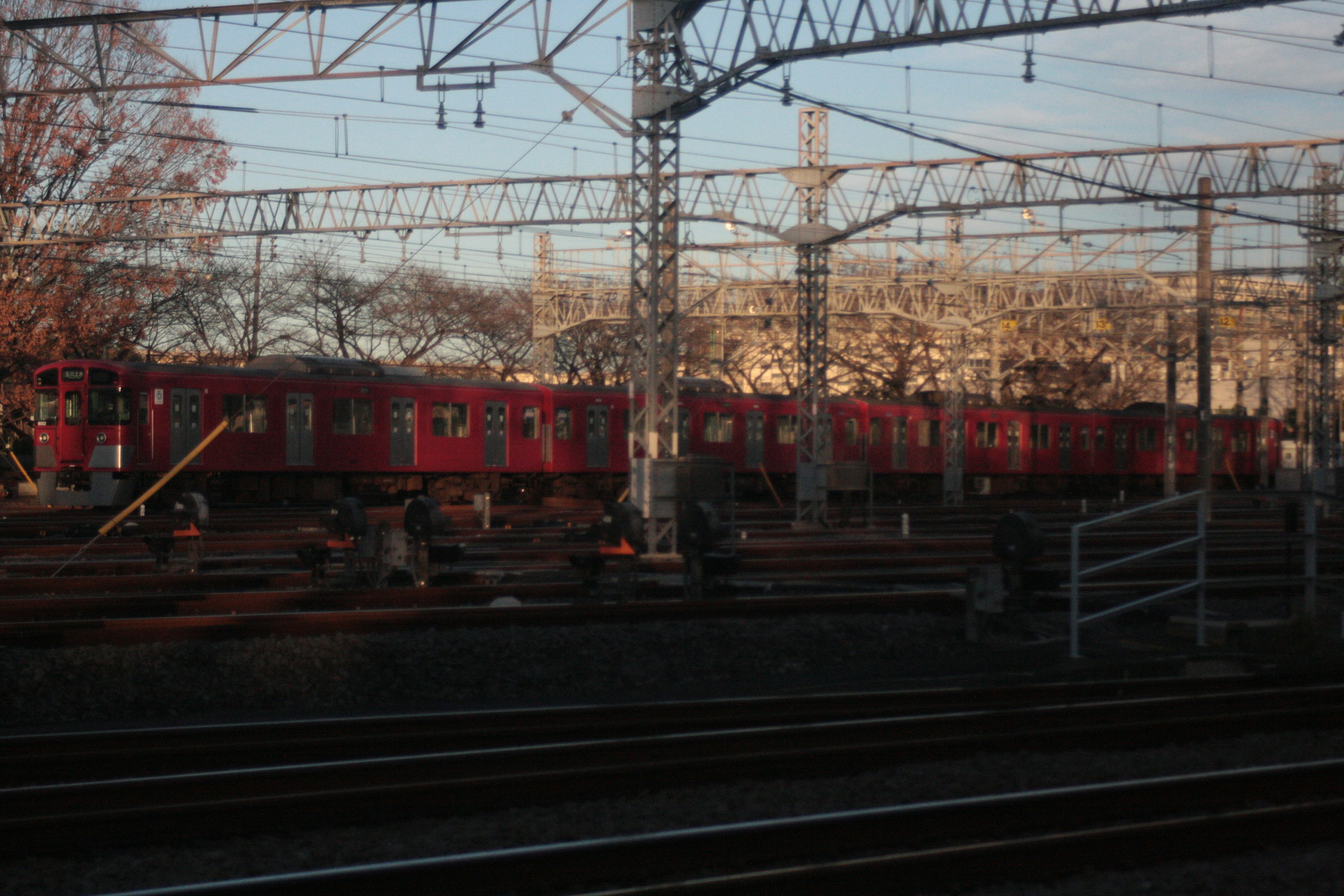 Kereta merah diparkir di rel di sebuah depot kereta