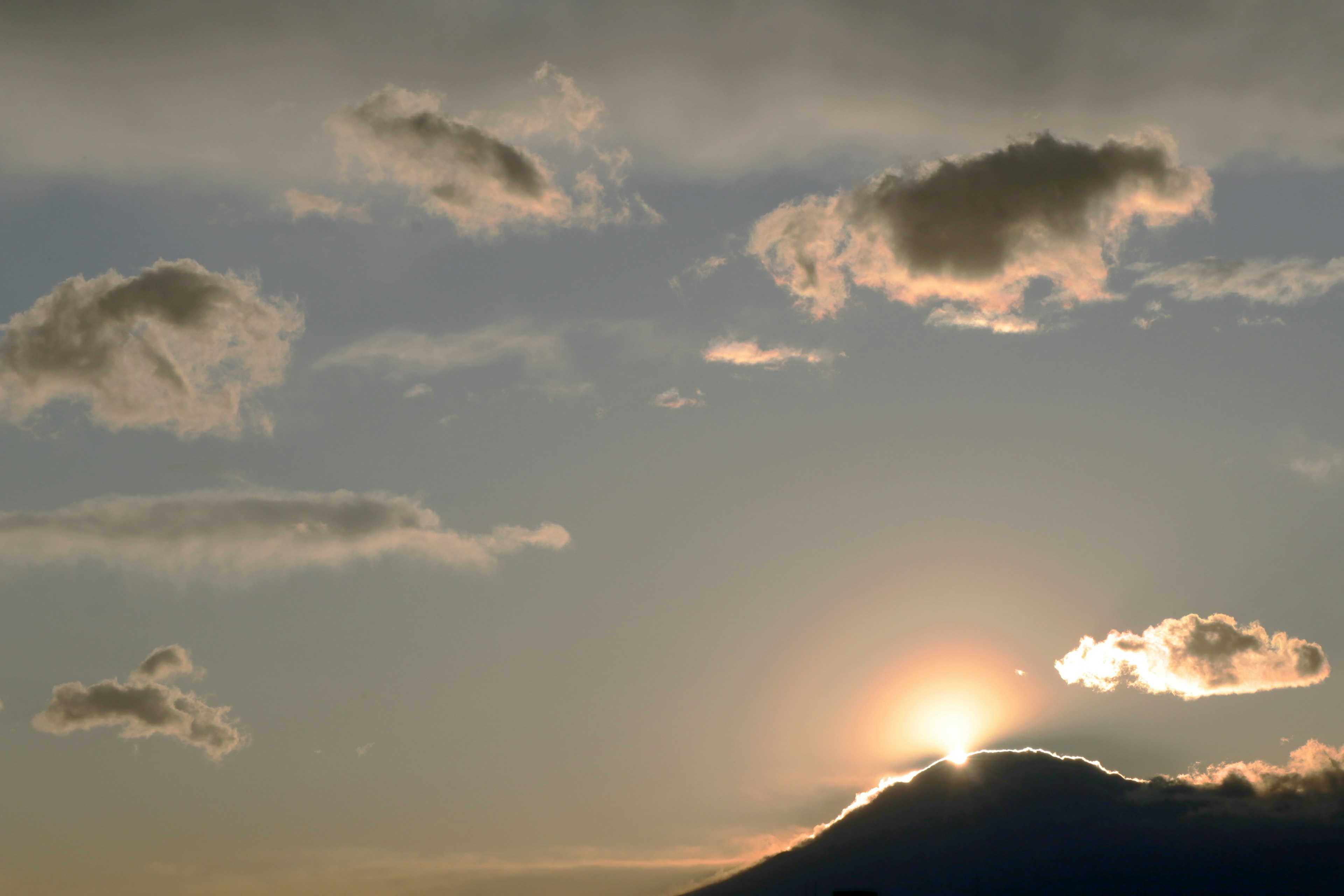 Sonnenaufgang über einem Berg mit Wolken am Himmel