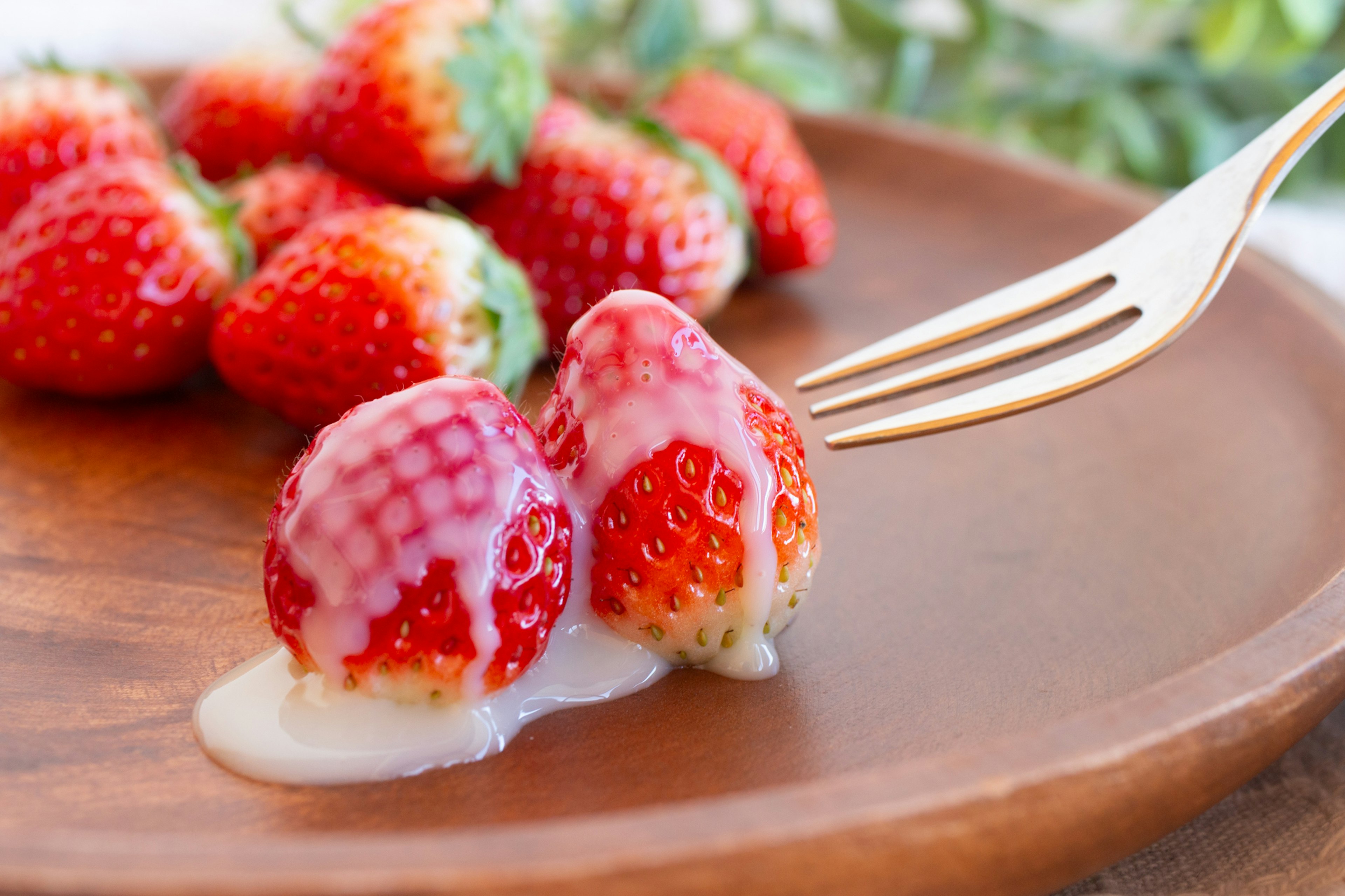 Fresh strawberries with cream on a wooden plate