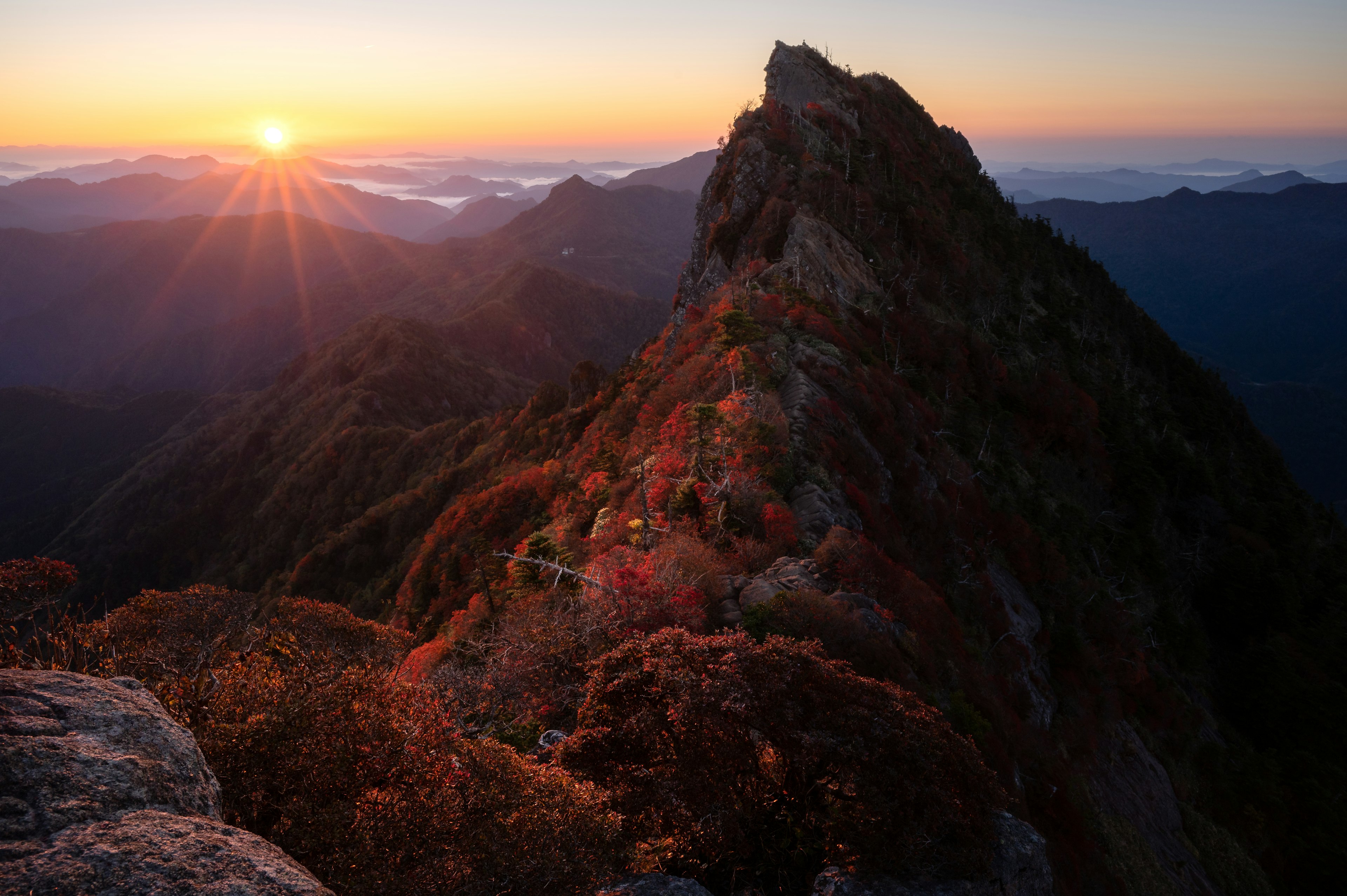 Alba che illumina il picco della montagna in autunno