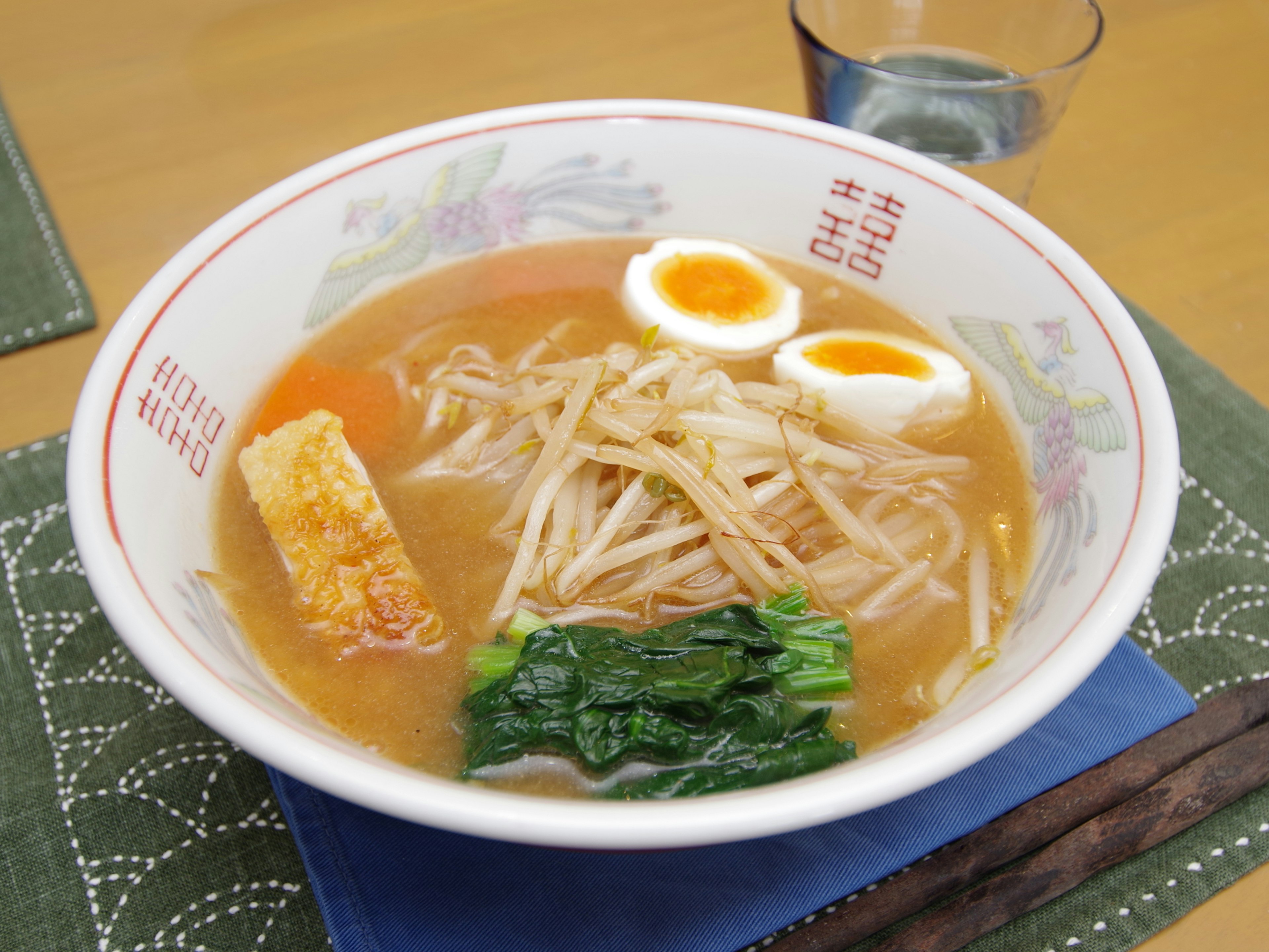 Un tazón de ramen delicioso cubierto con huevos pasados por agua y brotes de soja