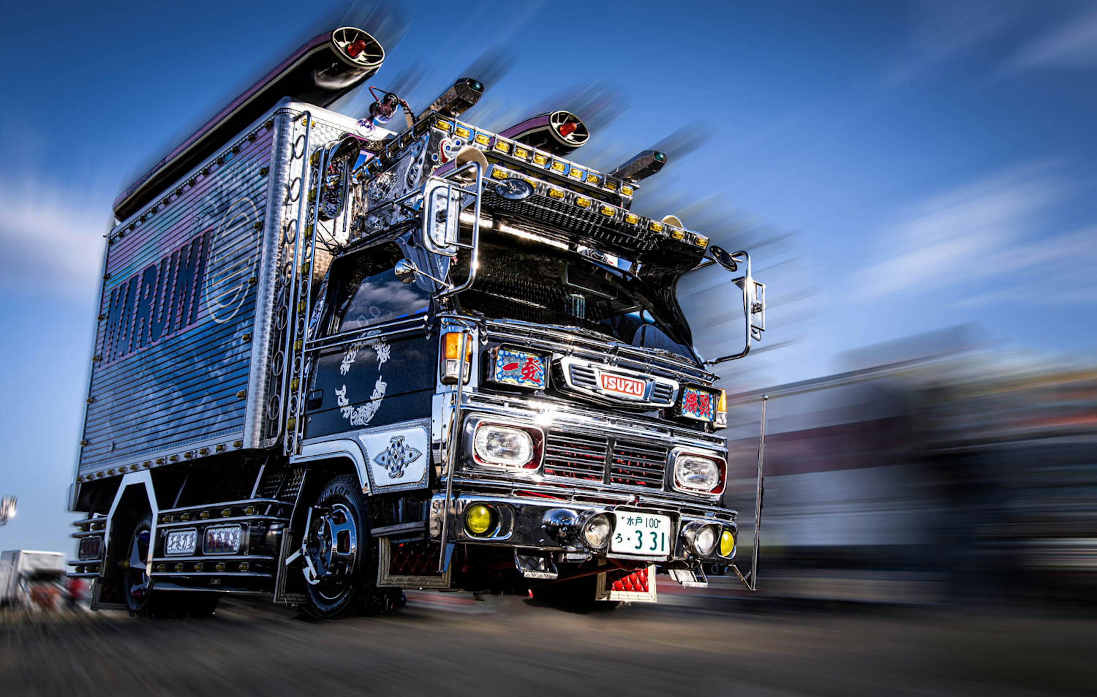 Colorful truck in motion with speakers and decorations on top