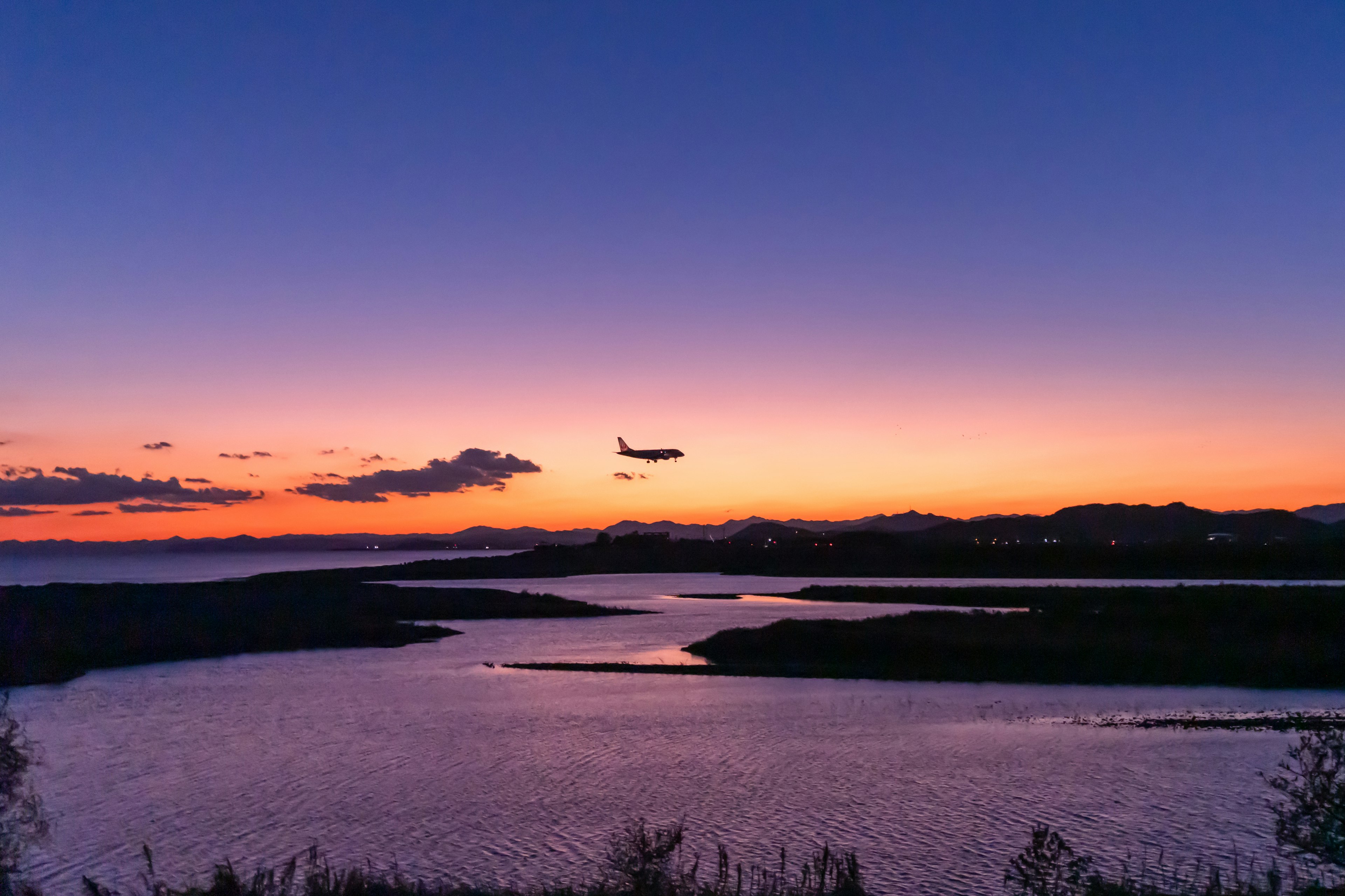 美しい夕焼けの空を背景に飛行機が飛ぶ景色