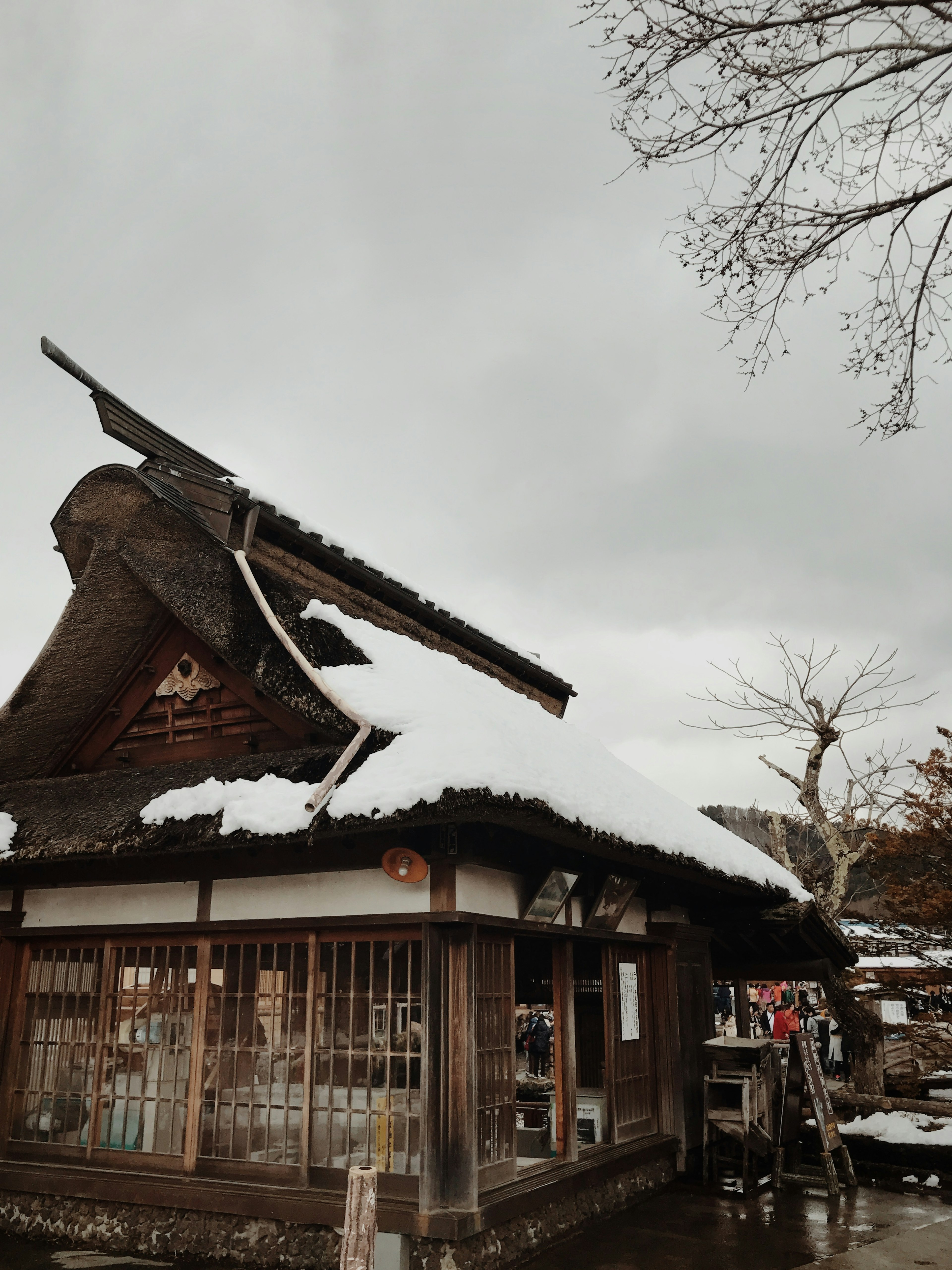 Casa japonesa tradicional con nieve en el techo y cielo nublado