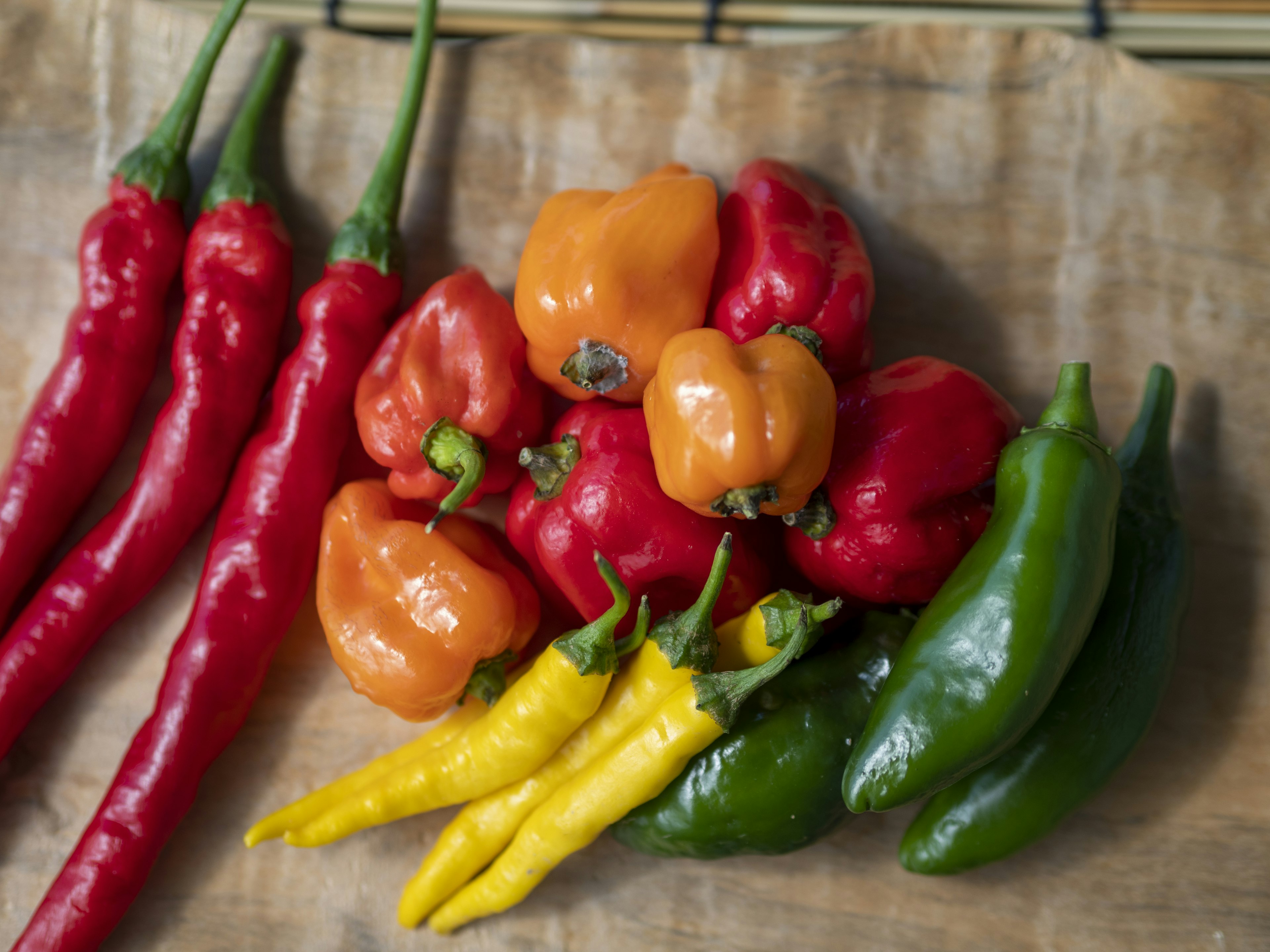 Colorful assortment of chili peppers on a wooden surface