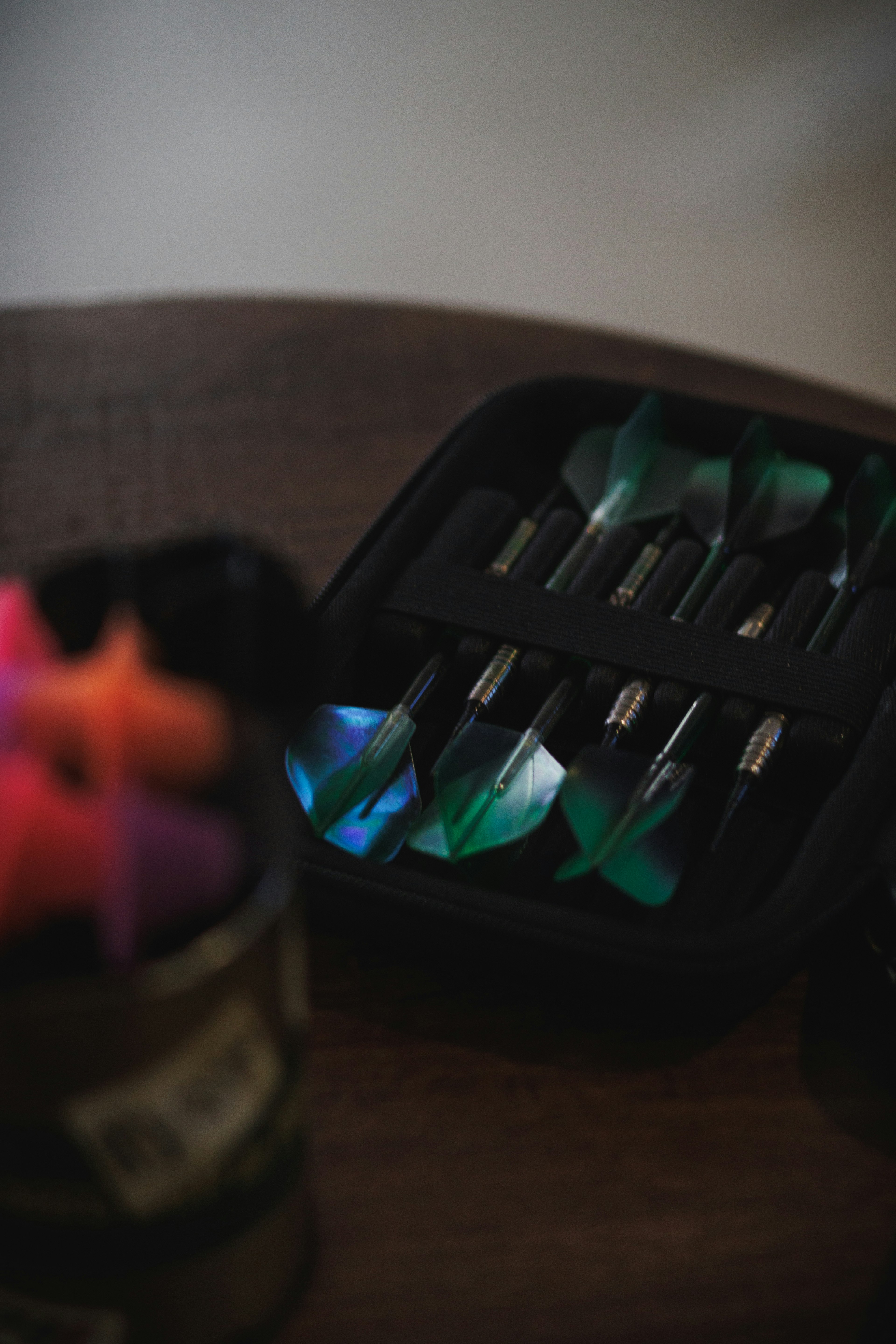 A dart set displayed in a black case featuring colorful darts