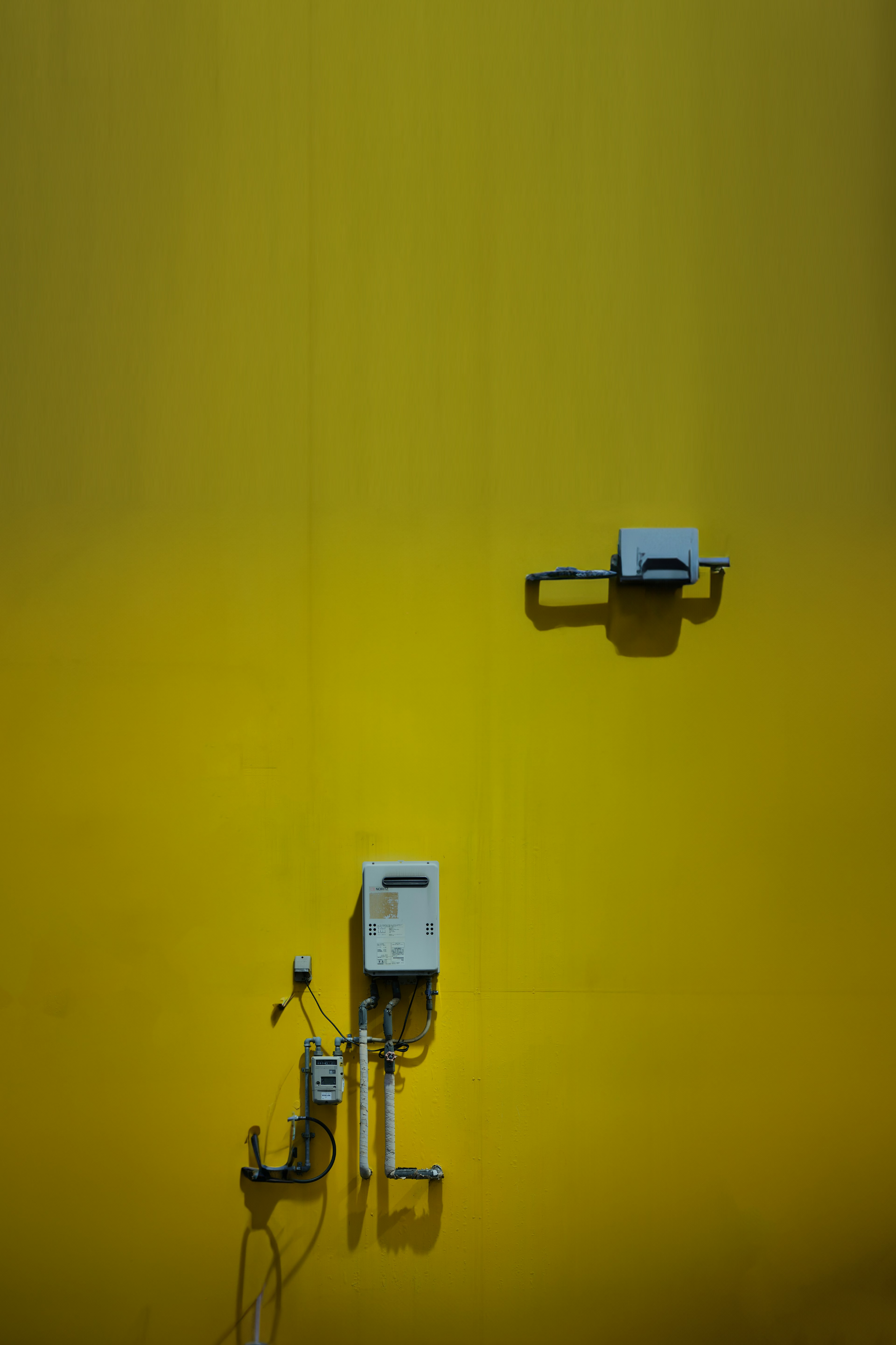 White electrical devices and wiring mounted on a yellow wall