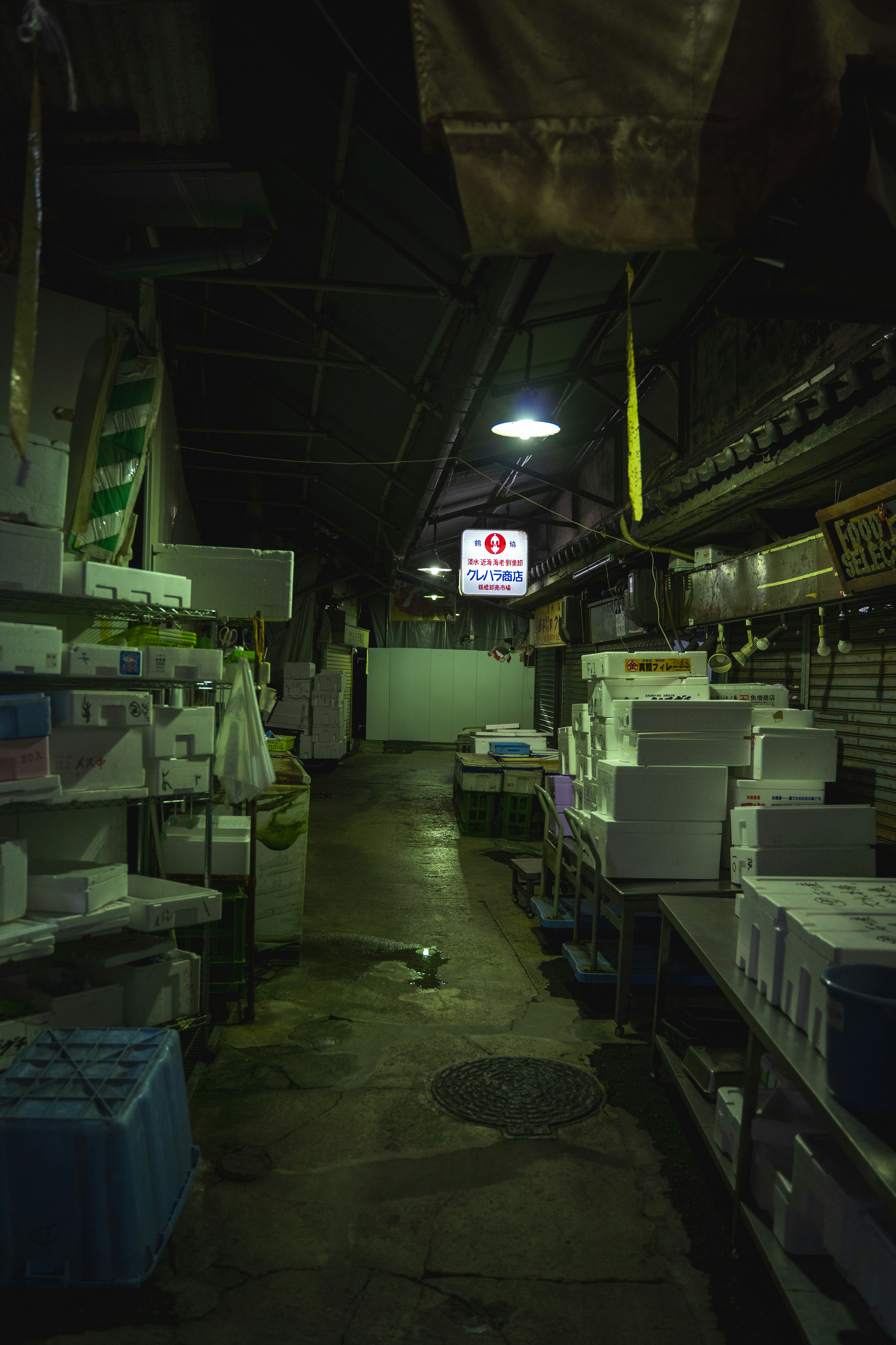 Pasillo de mercado débilmente iluminado con cajas y estantes