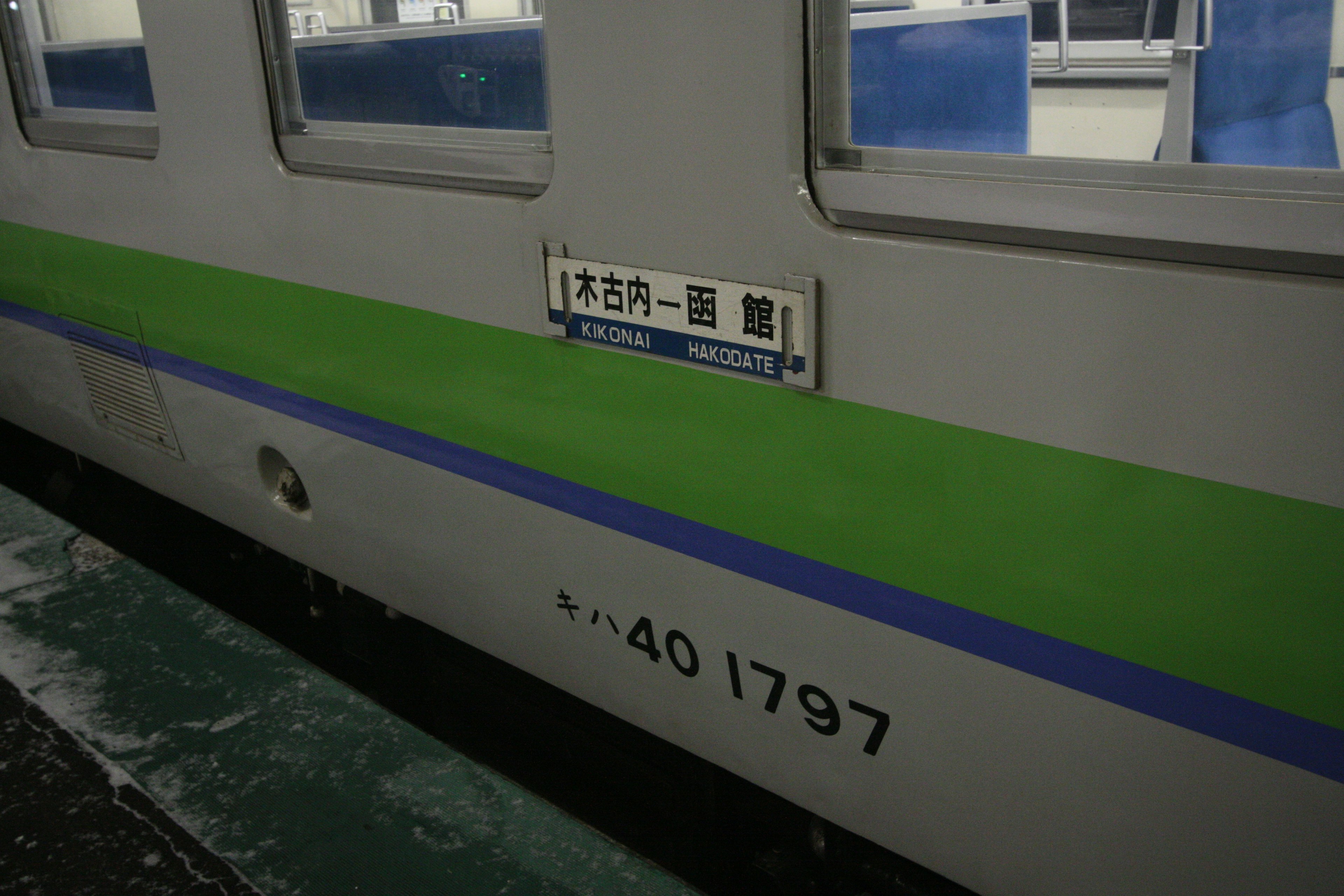 緑の帯が特徴的な電車の側面にある表示と番号