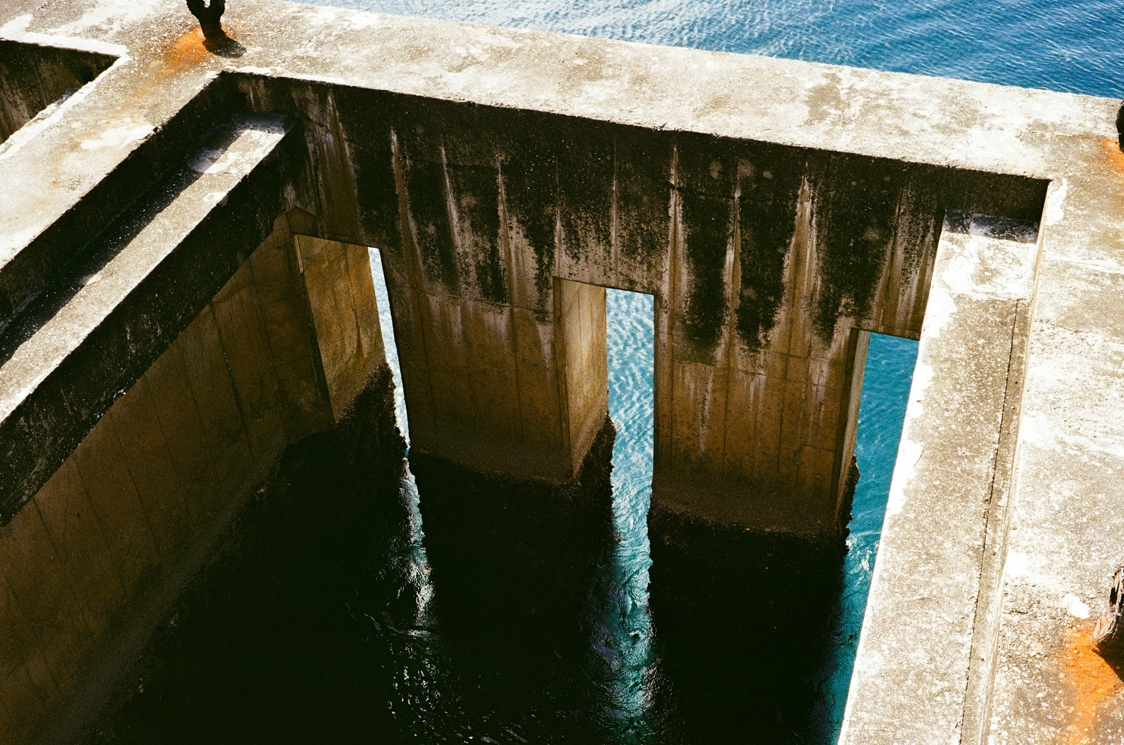 Nahaufnahme einer Betonstruktur, die sich im Wasser spiegelt