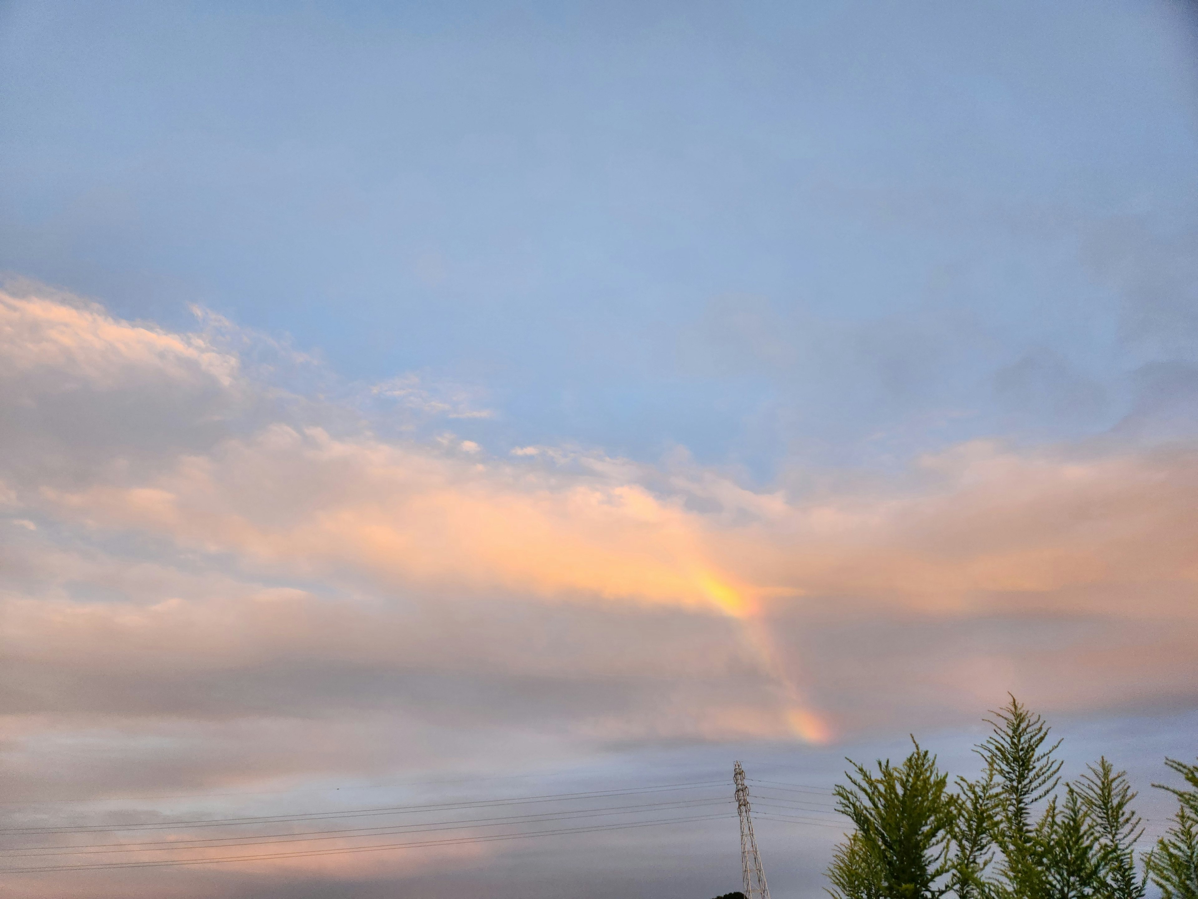 青空と雲の美しい風景に薄いオレンジ色の光が差し込む