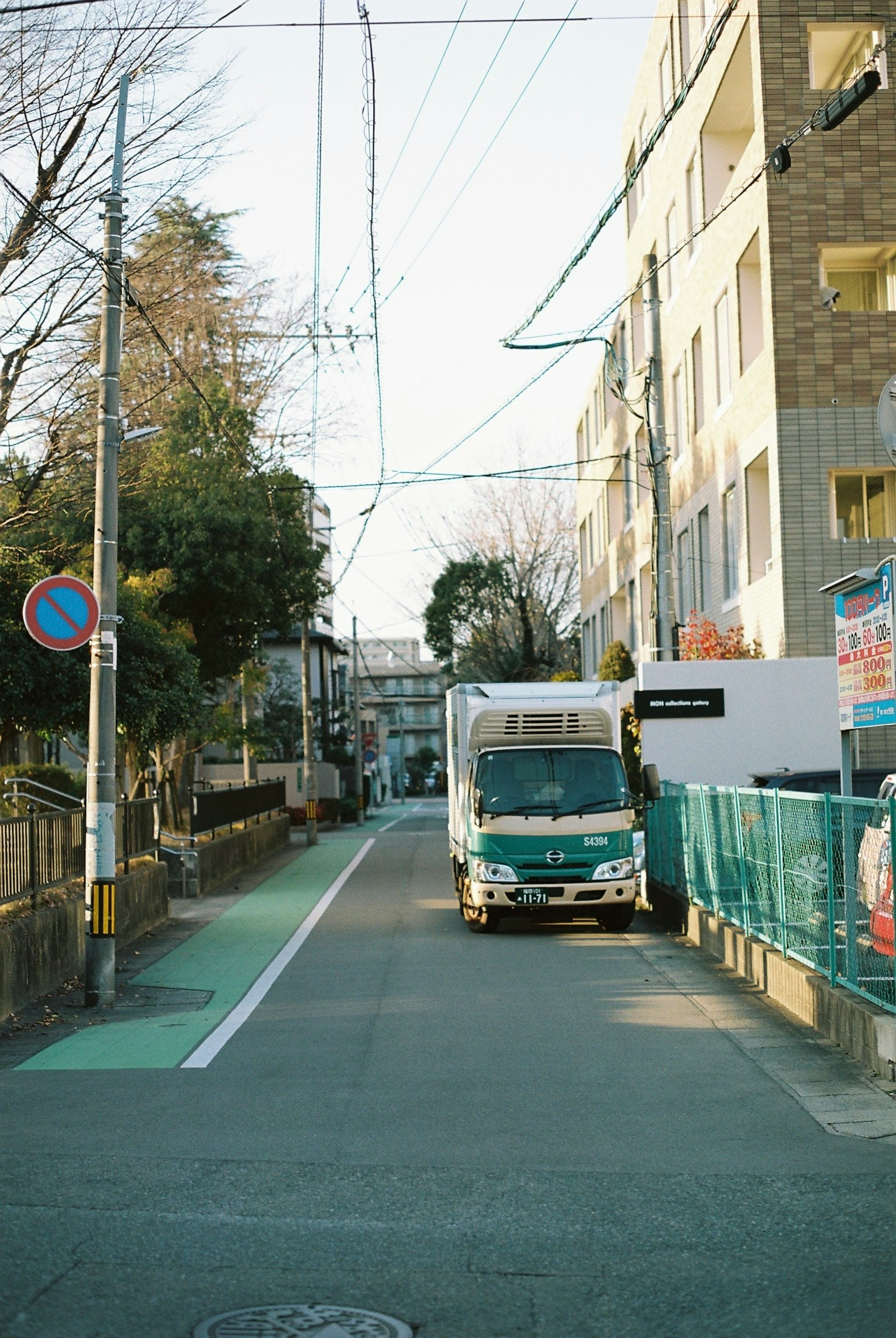 静かな住宅街の通りに停車しているトラックと周囲の建物