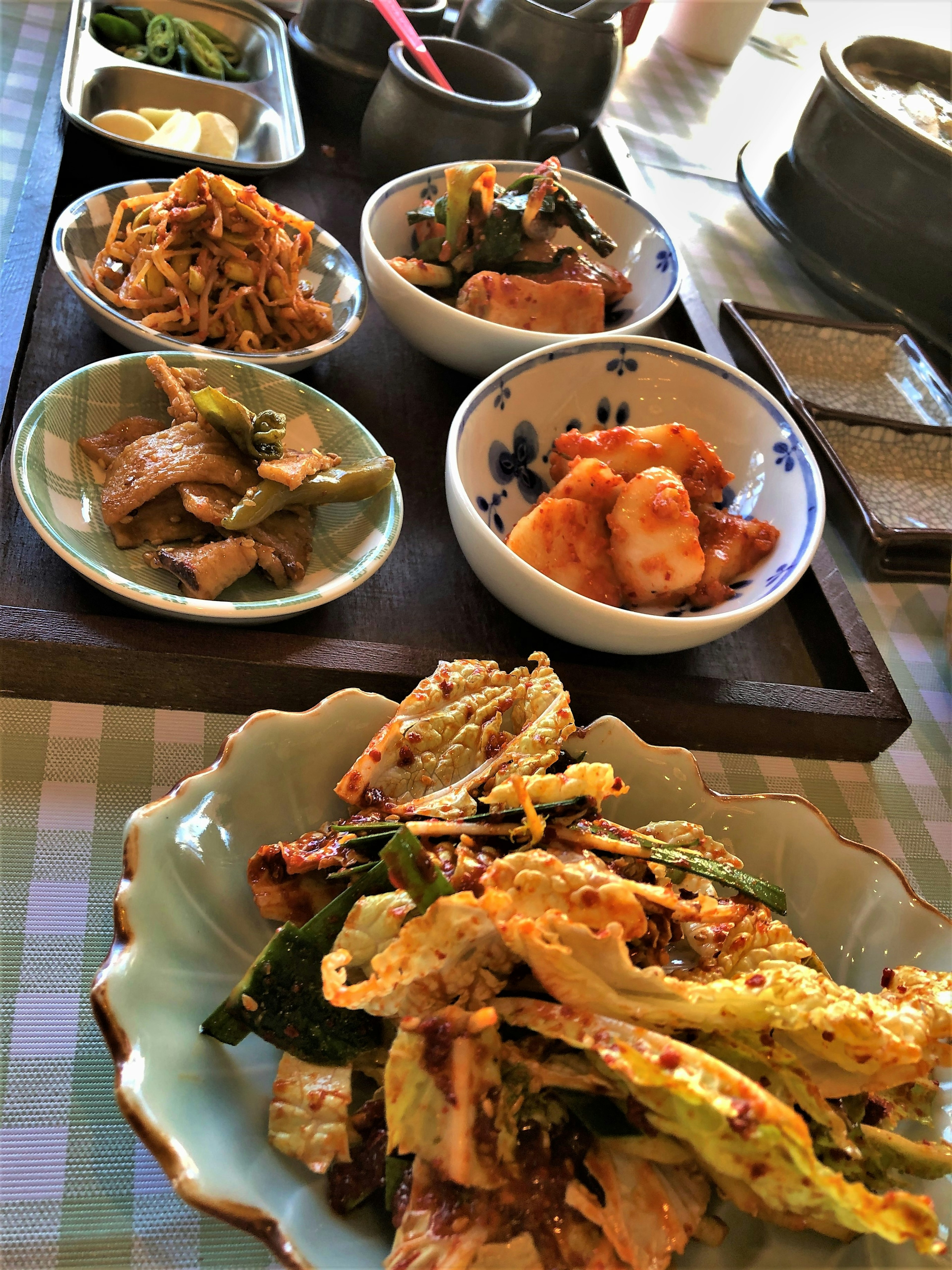 A spread of Korean dishes featuring various small bowls and a main platter