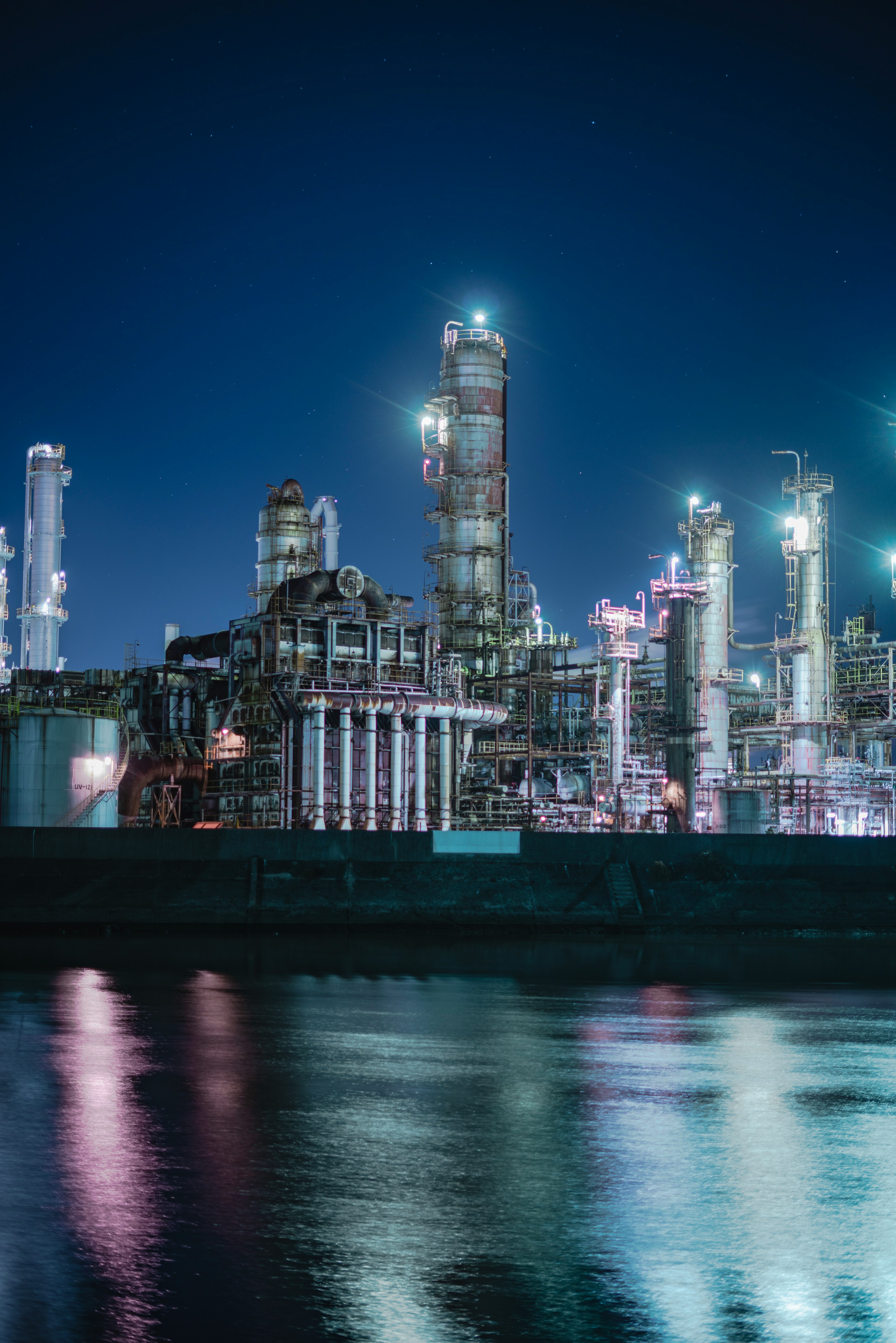 Industrial plant illuminated at night reflecting on water