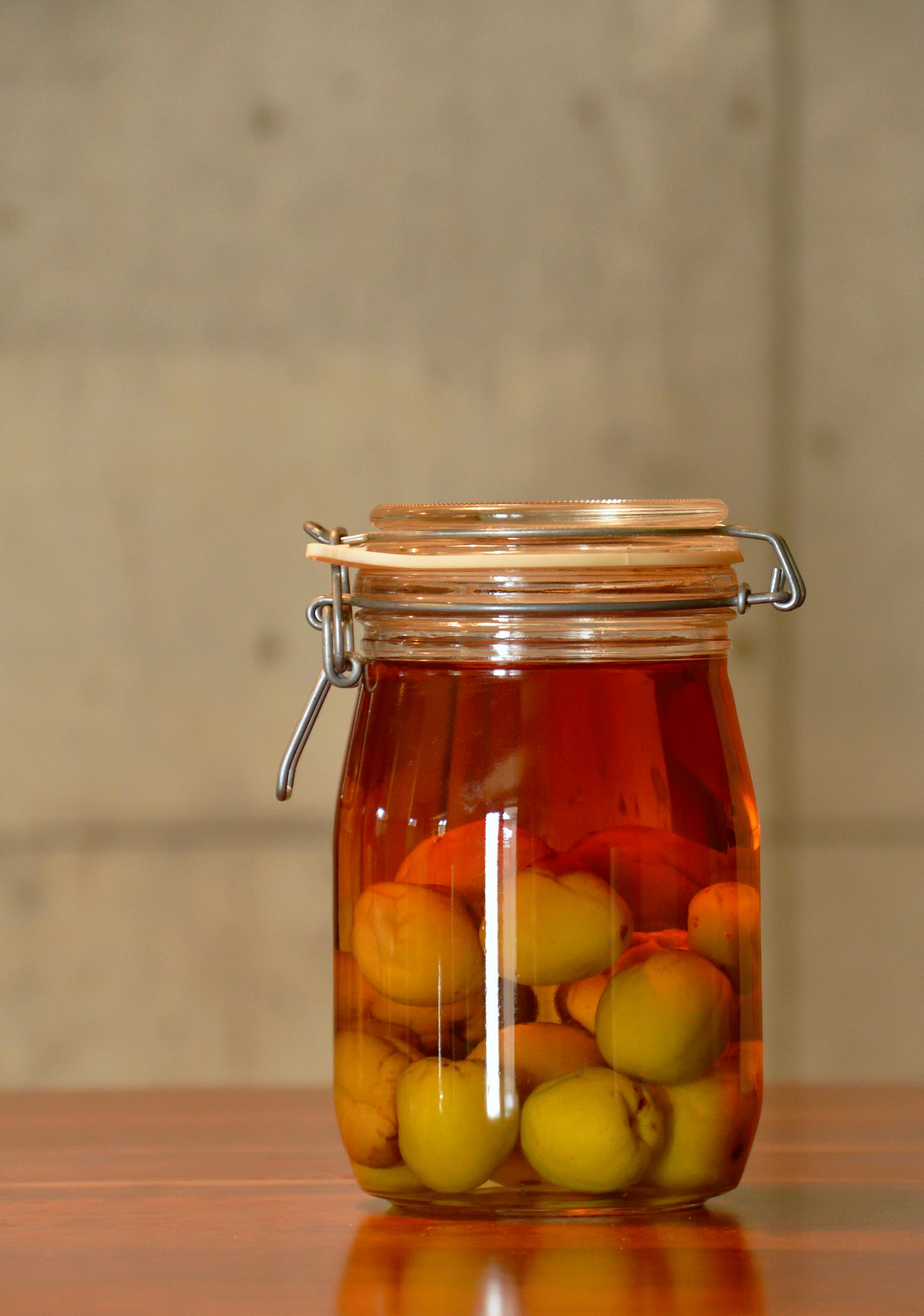 Un bocal en verre rempli de fruits jaunes immergés dans un liquide