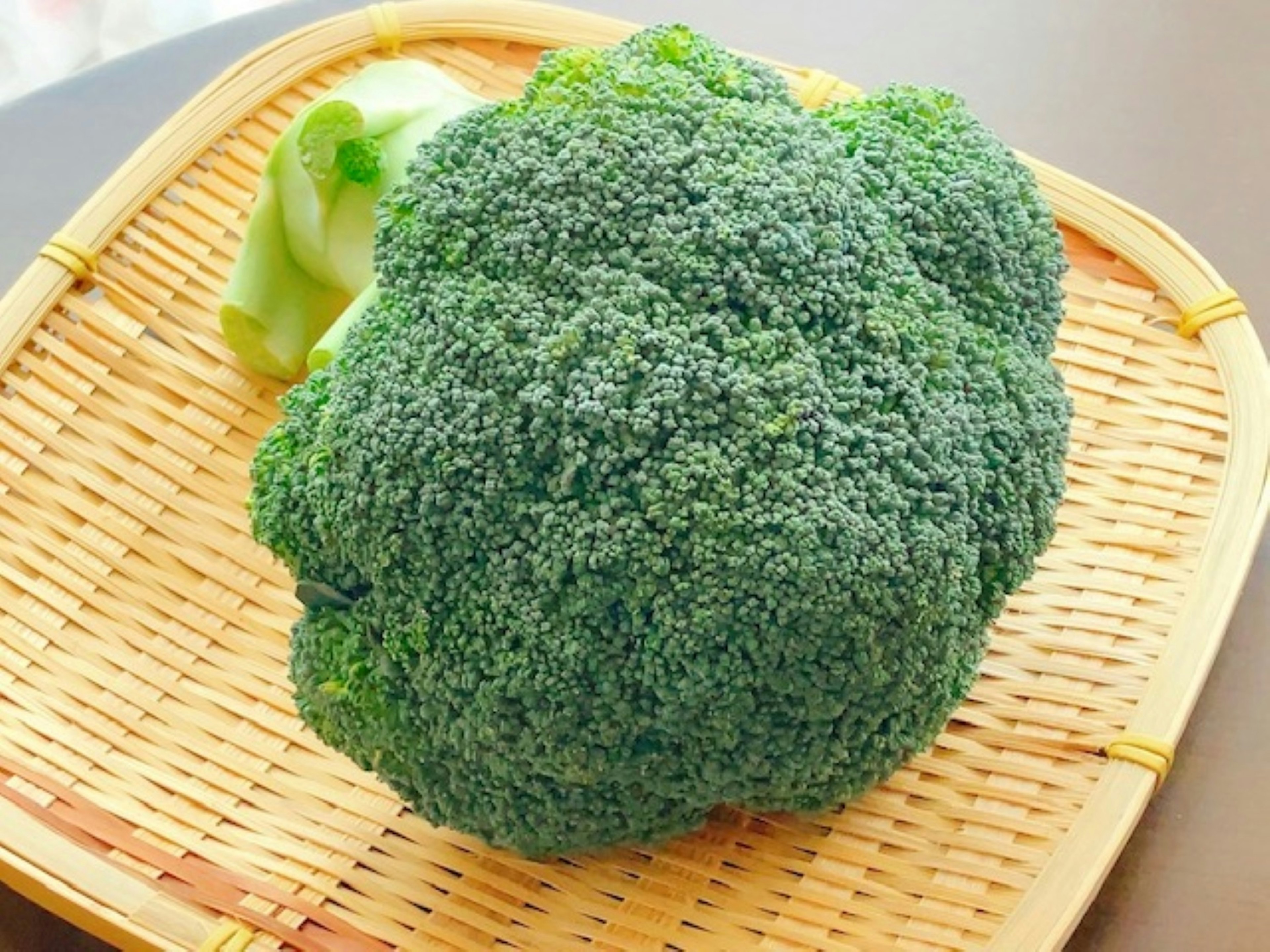 Fresh broccoli and part of cabbage in a woven basket