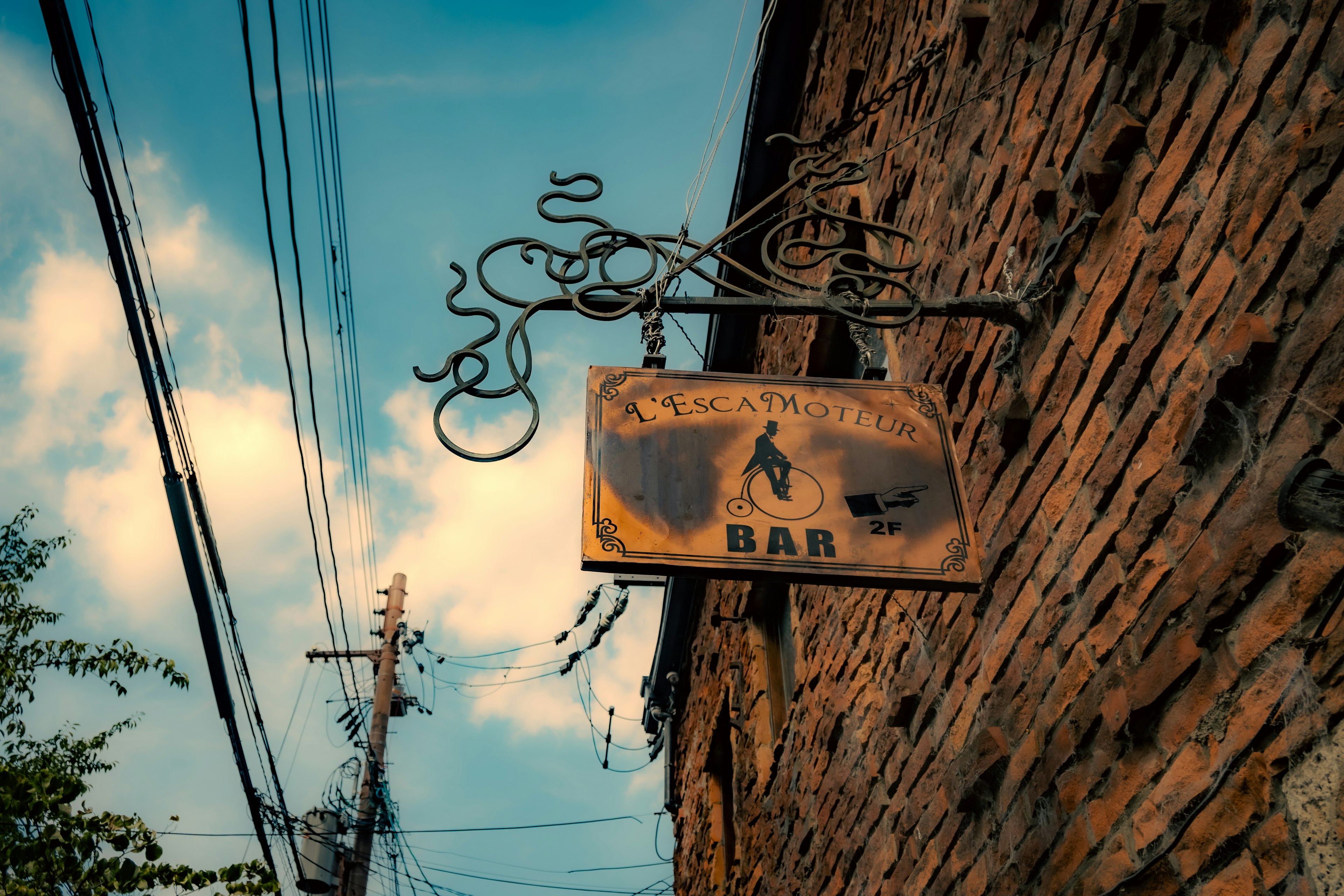 Panneau de bar suspendu à un vieux bâtiment en pierre avec ciel bleu