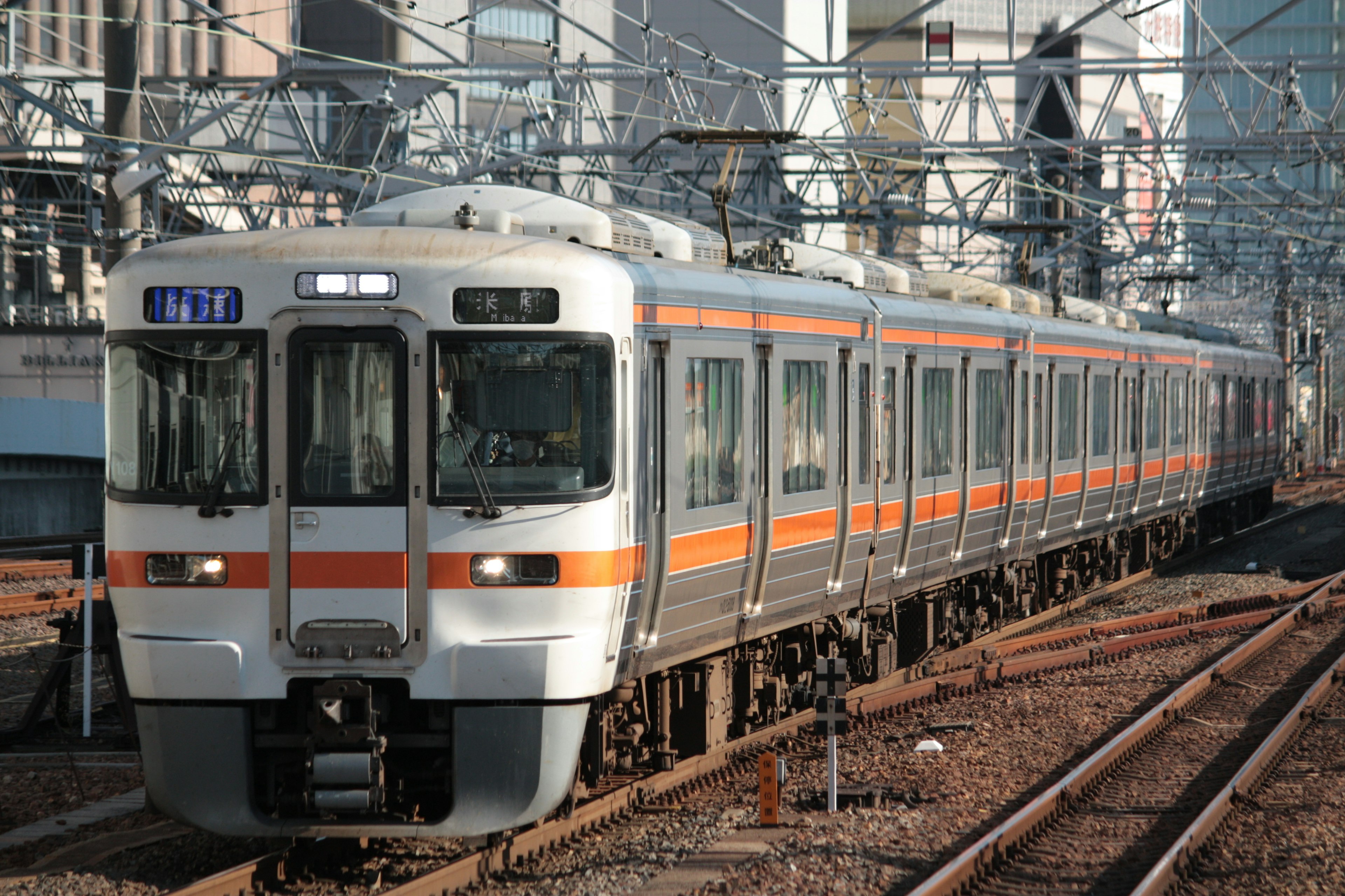 Un treno arancione e argento che corre sui binari